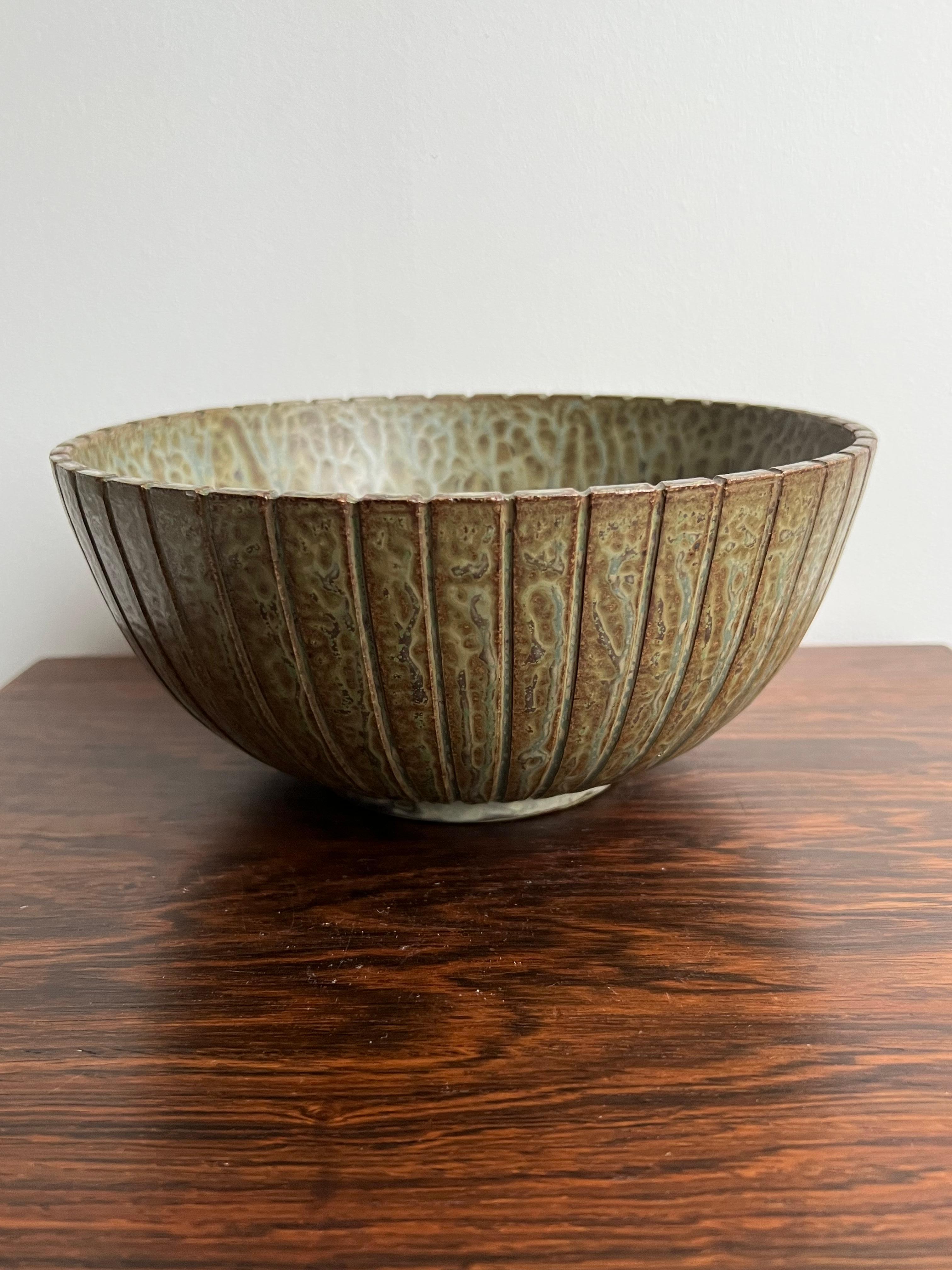 Arne Bang, bowl, own studio, Denmark 1930’s. The fluted exterior and the strictly geometric shape makes tis bowl very decorative in any interior. At the same time, it carries a speckled glaze in various shades of greens, grays and browns -and added