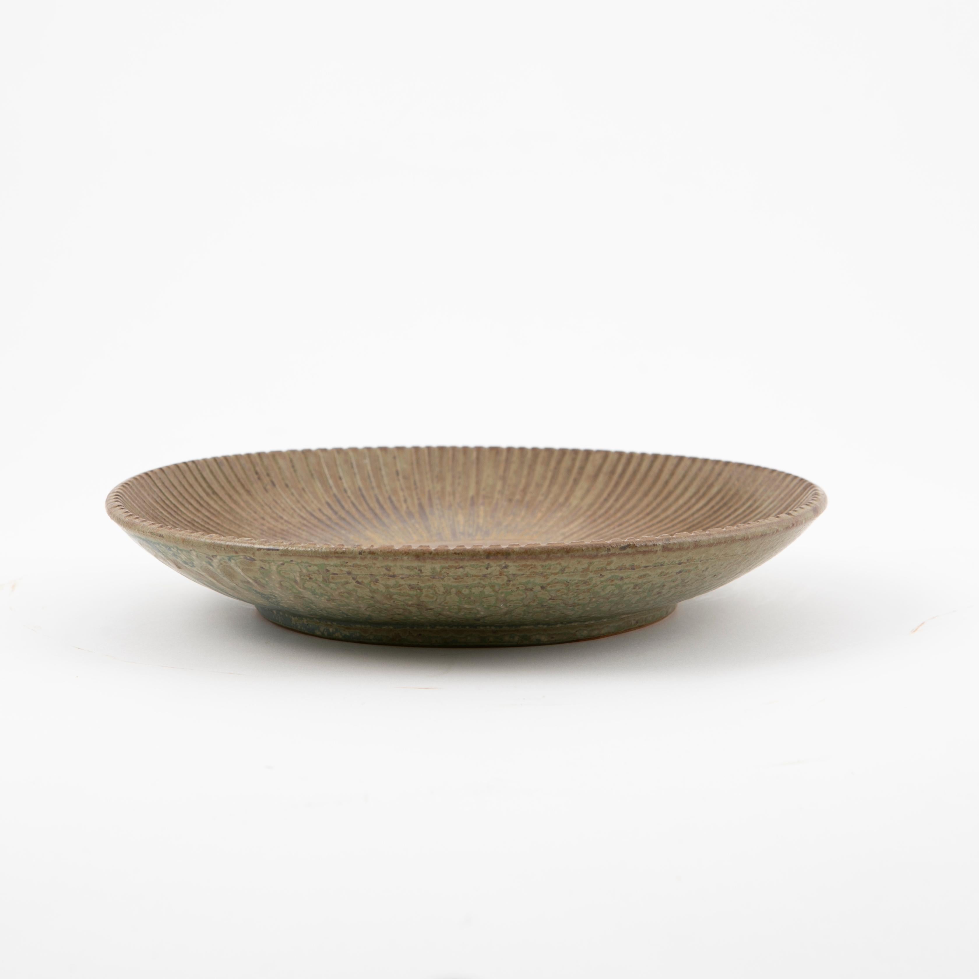 Arne Bang (Danish, 1901-1983)
Ribbed stoneware dish in earthy green glazing. Outer surface in shades of brown, green and cyan. Model no. 91.
In perfect condition. 
Signed with monogram AB.
Denmark 1940's.