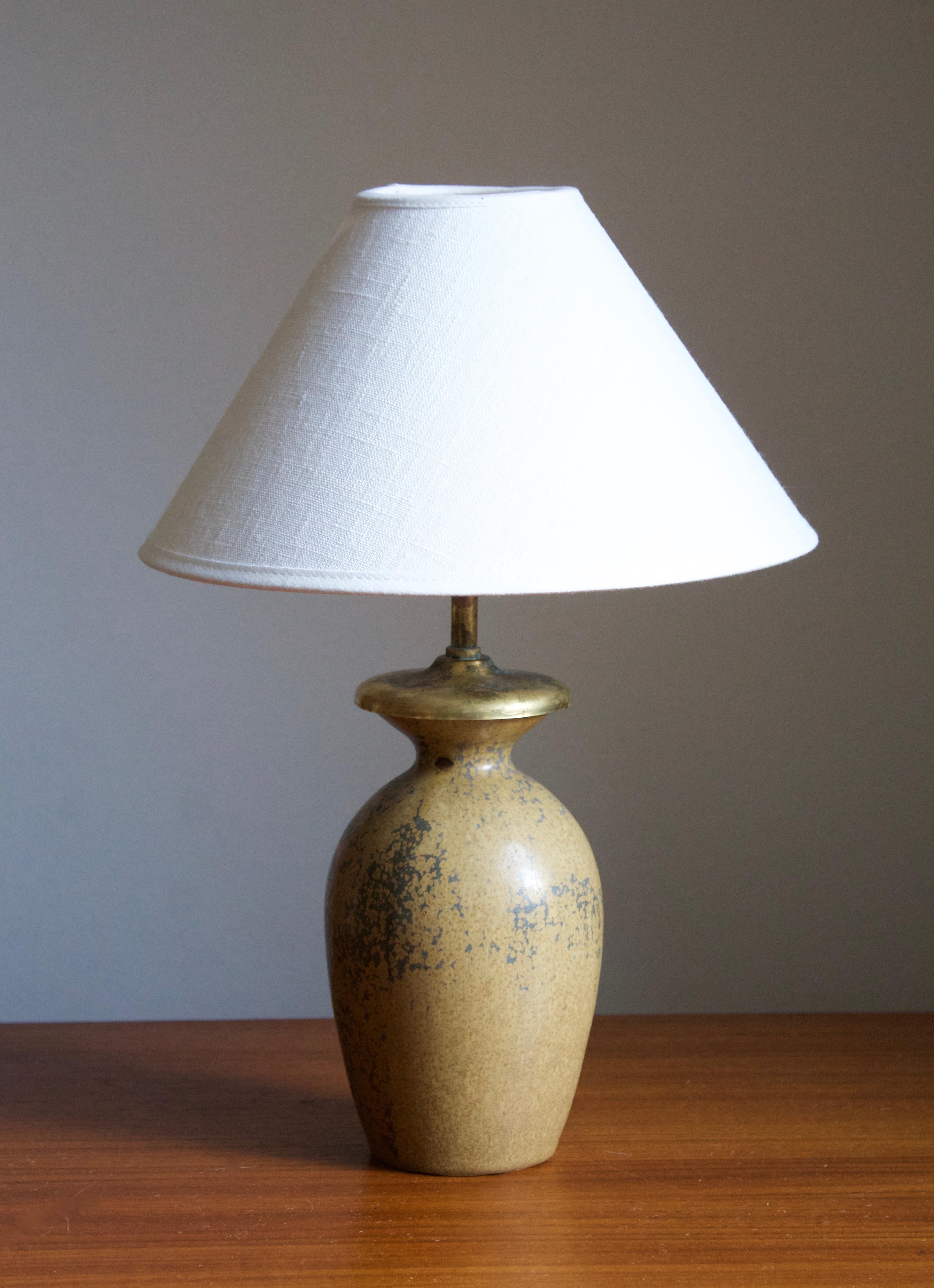 A table lamp. Designed by Arne Bang, produced c. 1927. Glazed stoneware. 

Stated dimensions exclude the lampshade. Stated height includes socket. Sold without lampshade.

Glaze features a beige color.

Other designers of the period include Axel