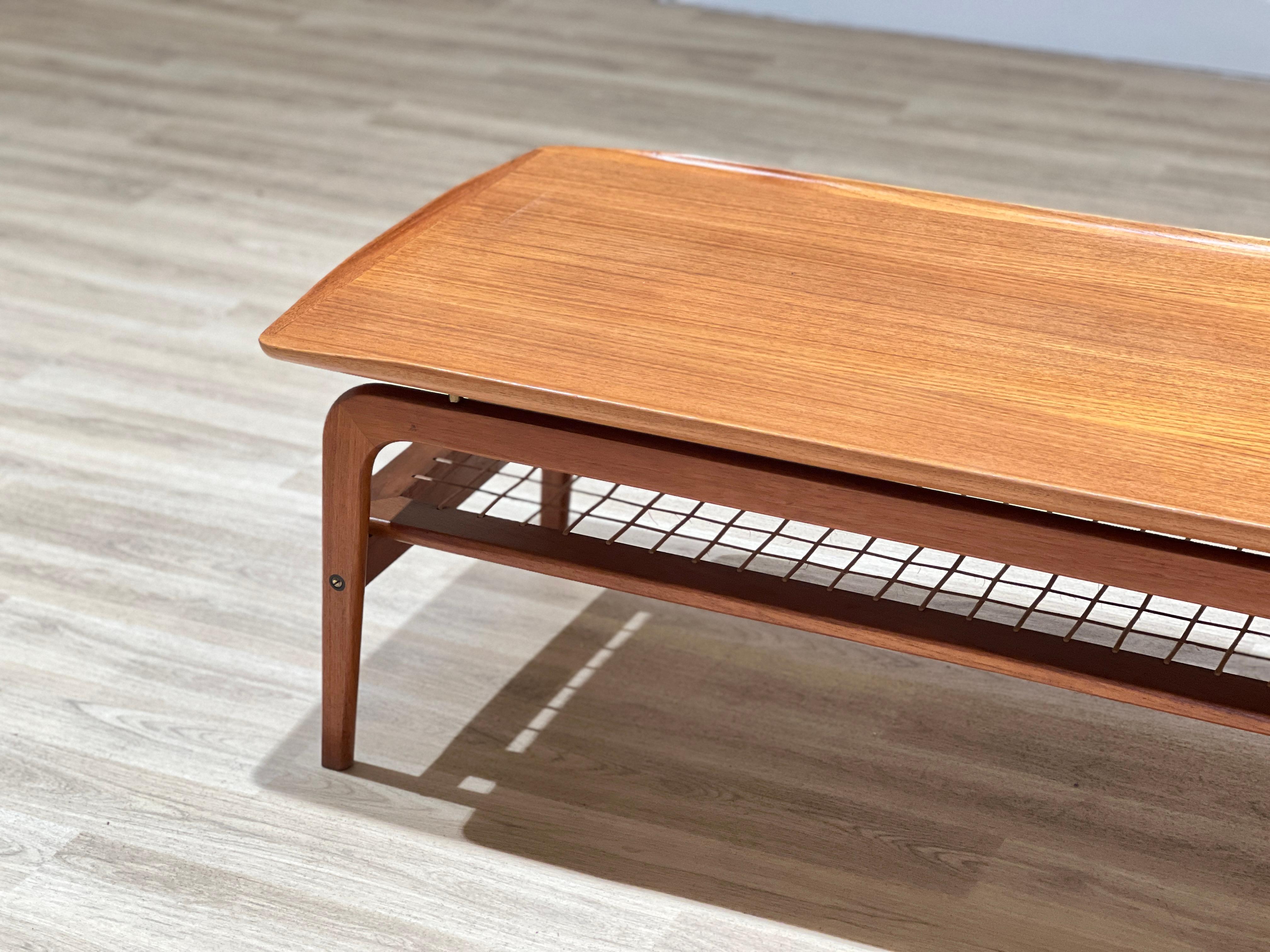 This beautifully designed coffee table by Arne Hovmand Olsen is a masterpiece of craftsmanship and elegance. Made in Denmark in the 1960s, it was created for the renowned cabinet maker Mogens Kold. The table features a stunning handcrafted rattan
