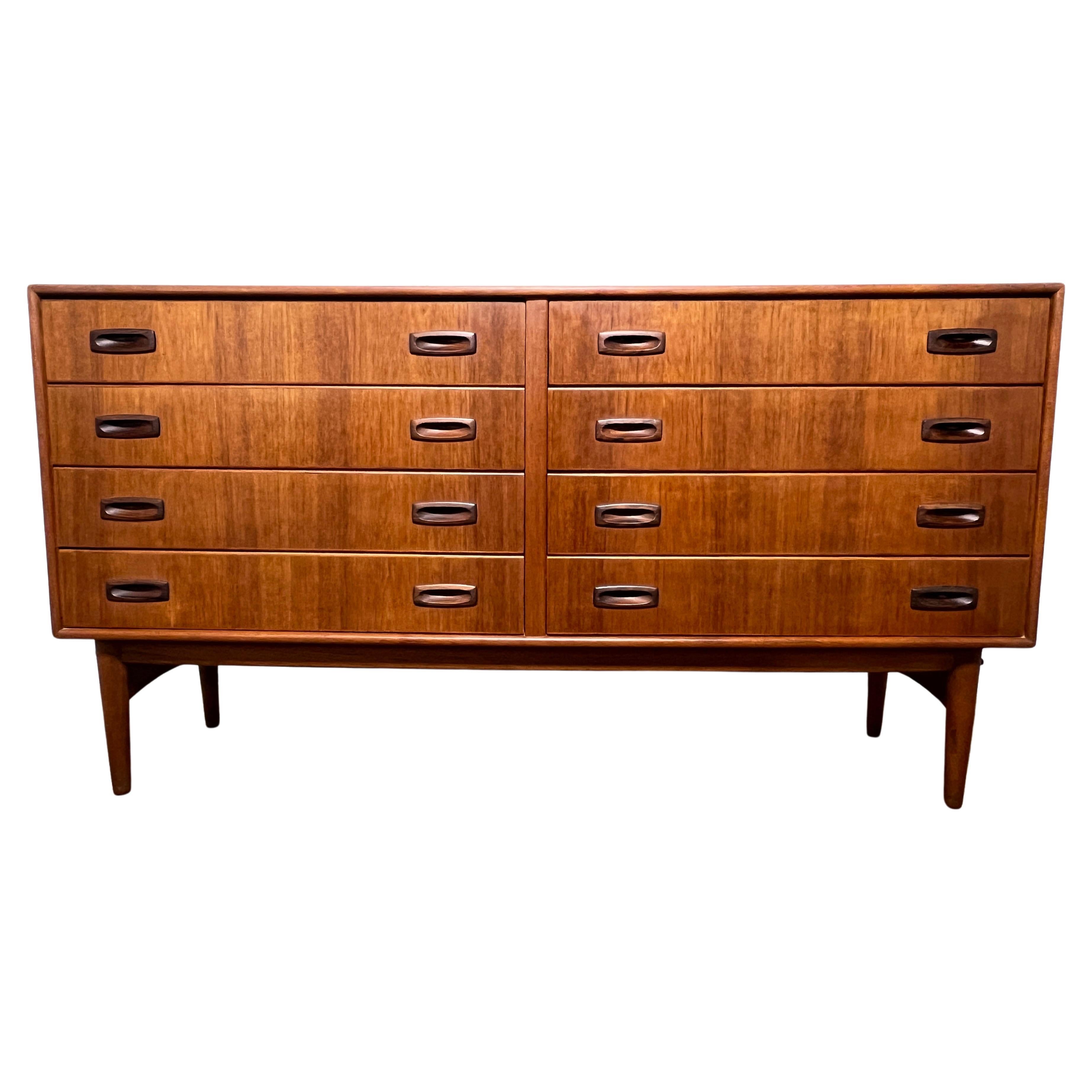 Eight drawer dresser in teak with contrasting rosewood handles by Arne Hovmand-Olsen, Denmark, ca. 1960s.