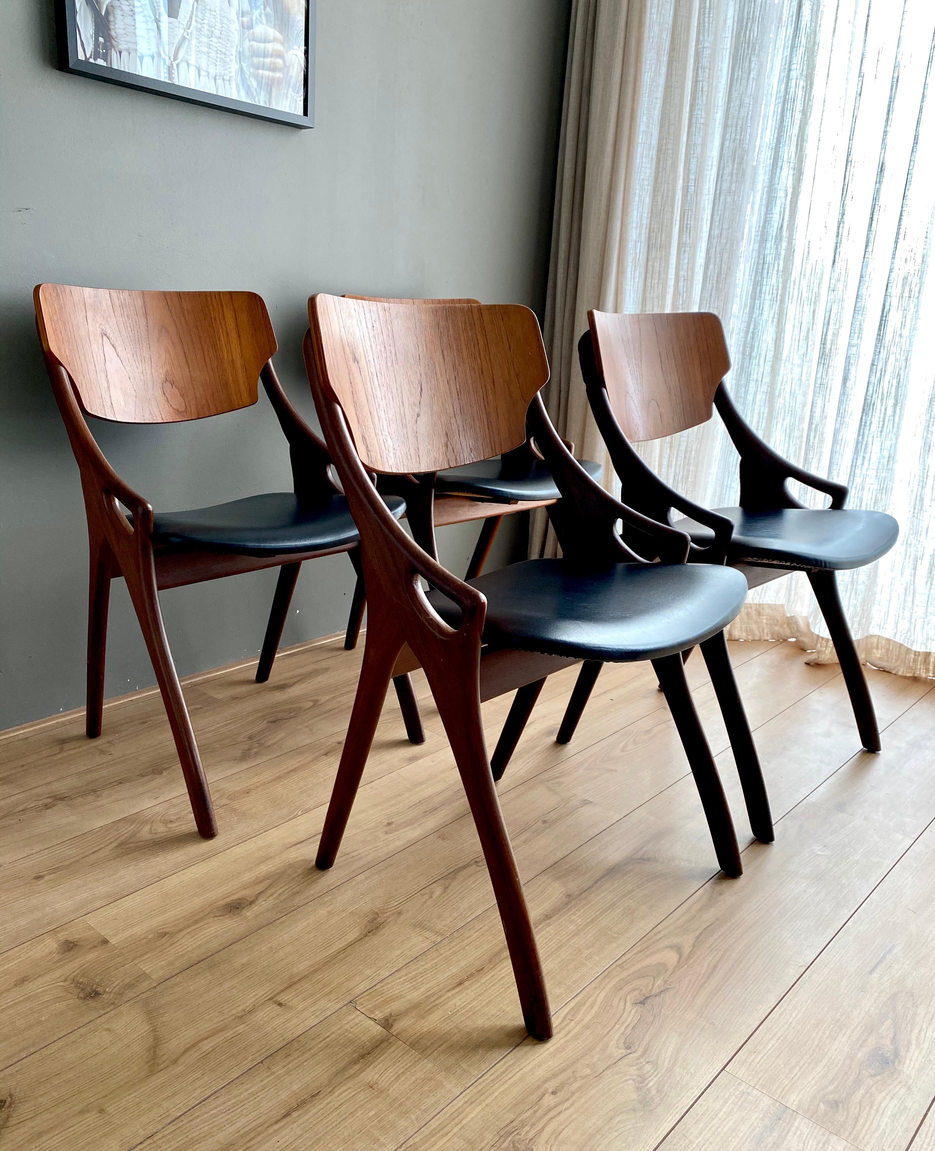 Absolutely stunning set of four dining room chairs, designed by Arne Hovmand Olsen for Mogens Kold Mobelfabrik, Denmark. The chairs feature a warm colored teak base with the original Black Leatherette upholstery. Little wear consistent with age and