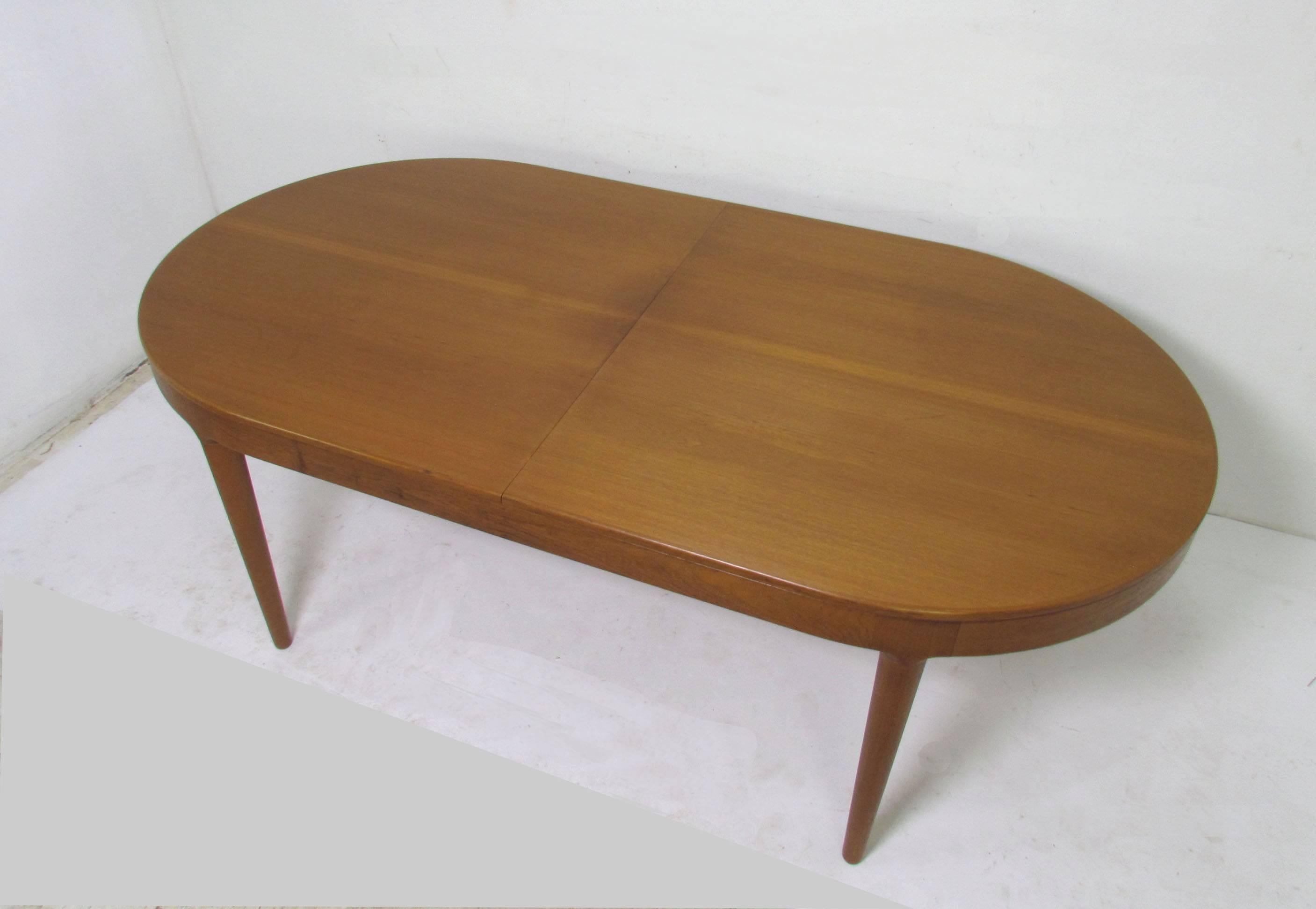 Attractive wide-skirted Danish teak oval dining table with two butterfly extension leaves, designed by Arne Hovmand-Olsen for Mogens Kold, circa 1960s.

Each leave is 19.5