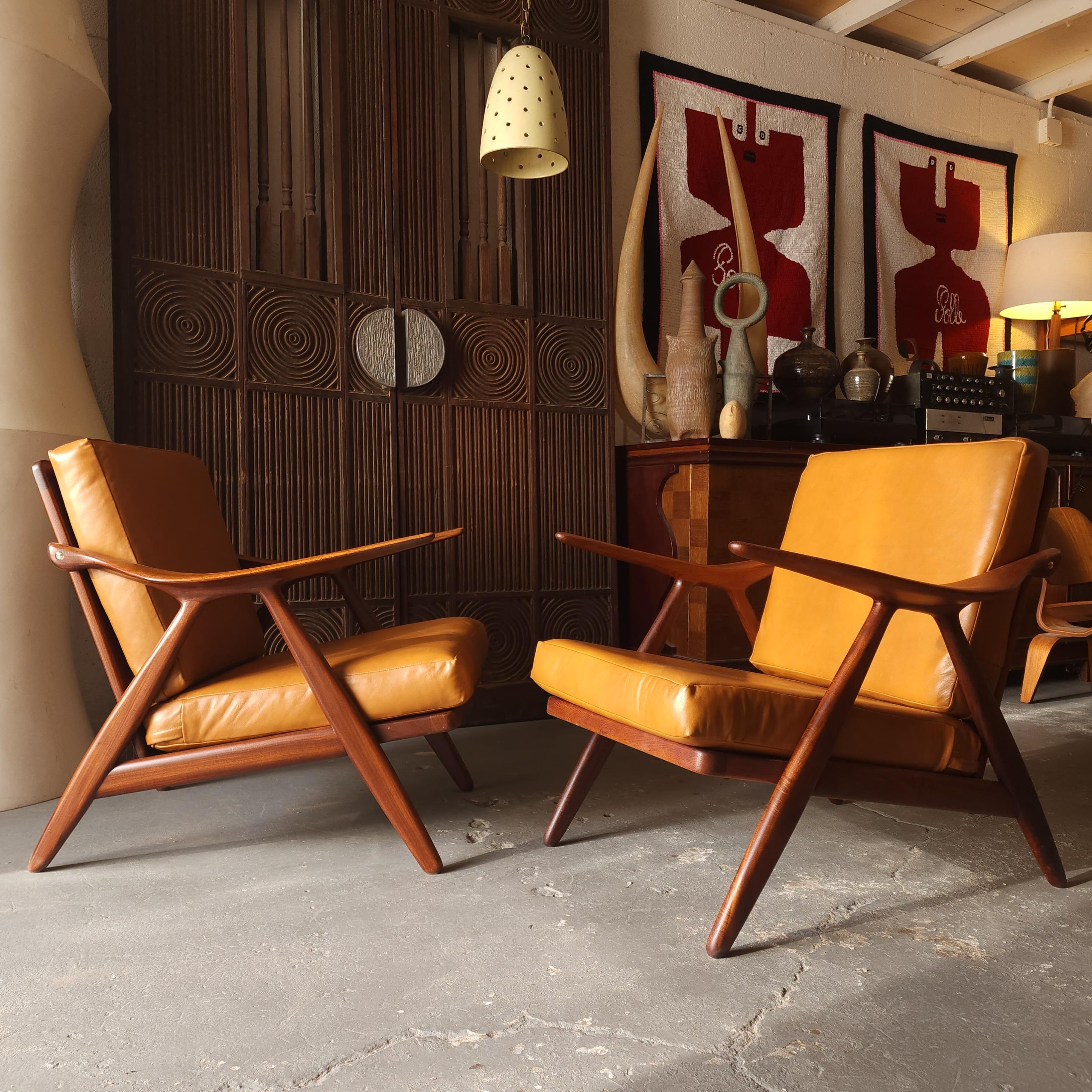 These rich teak lounge chairs by Arne Hovmand Olsen have been refinished and reupholstered. They have such a striking design that encompasses both form and function. The slope of the arm fits the body so well, which is indicative of Hovmand Olsen.