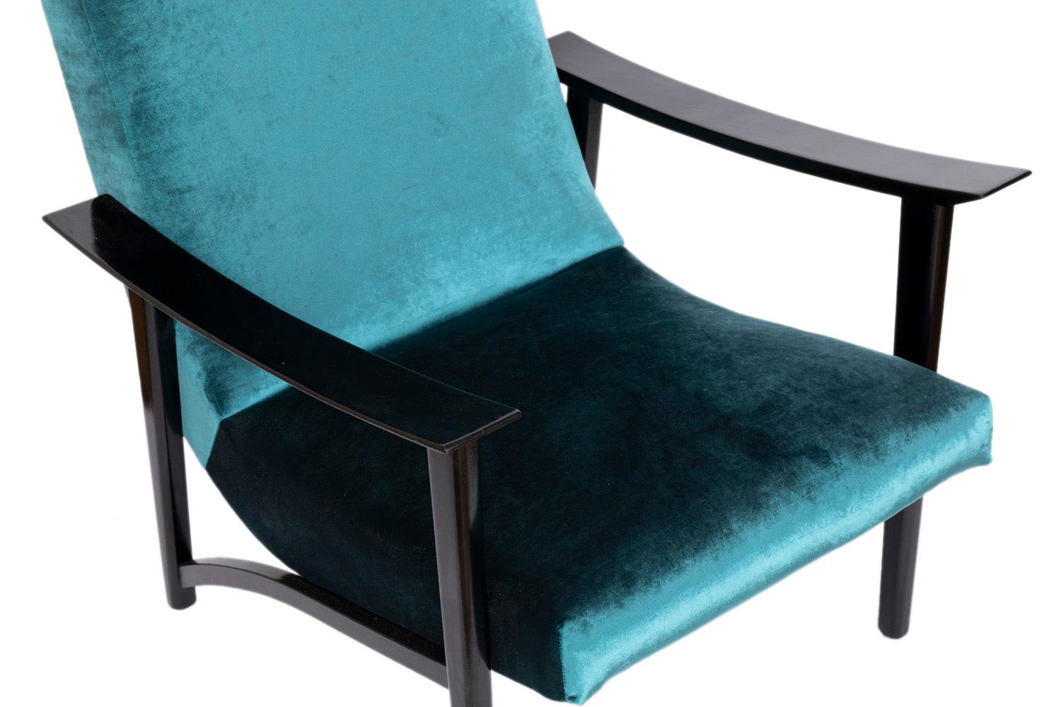 Pair of armchairs in black lacquered wood and blue velvet. Slightly curved armrests supported by cone-shaped legs. Curved stretcher bars link legs on armchairs each side.

Scandinavian work in the style of Arne Hovmand Olsen, realized in