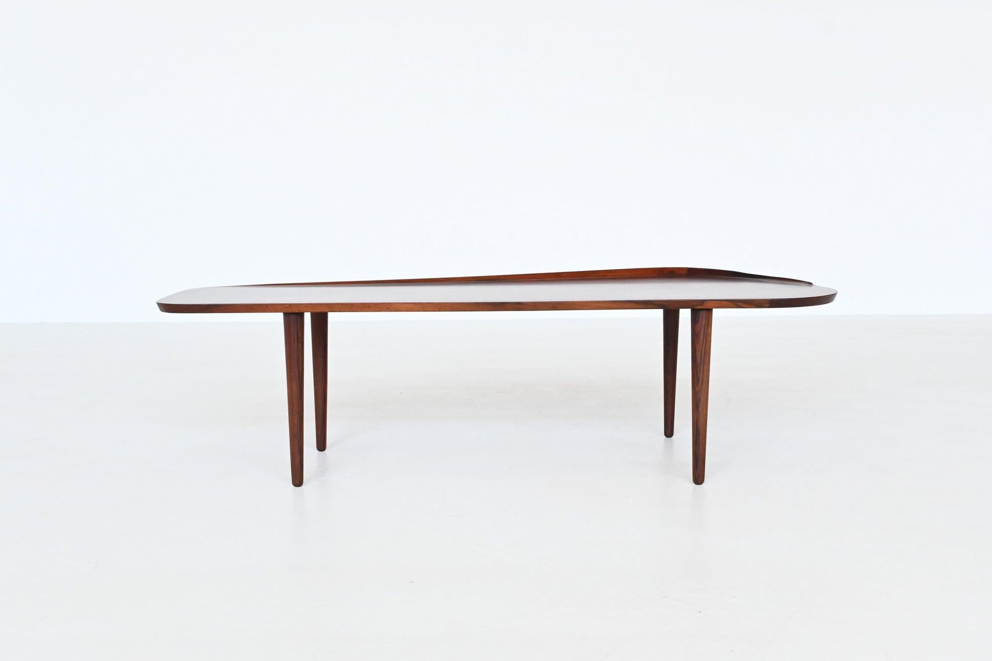 Beautiful long shaped coffee table designed by Arne Hovmand-Olsen for Jutex, Denmark 1958. The table has a nice asymmetrical surfboard-shaped top and the legs are slightly tapered, which is a subtle yet important detail. The rising edge at the back