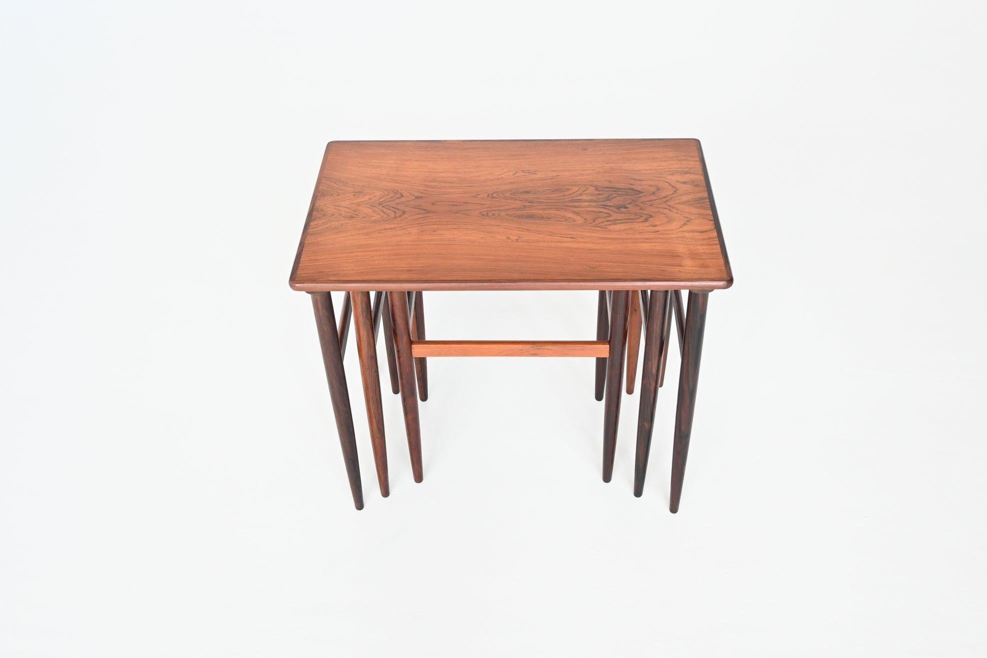 Beautiful shaped set of three nesting tables designed by Arne Hovmand Olsen, Denmark 1960. This set of nesting tables is made of very nice grained rosewood. They give a minimalist look due to the slender legs. Highly decorative set of nesting tables