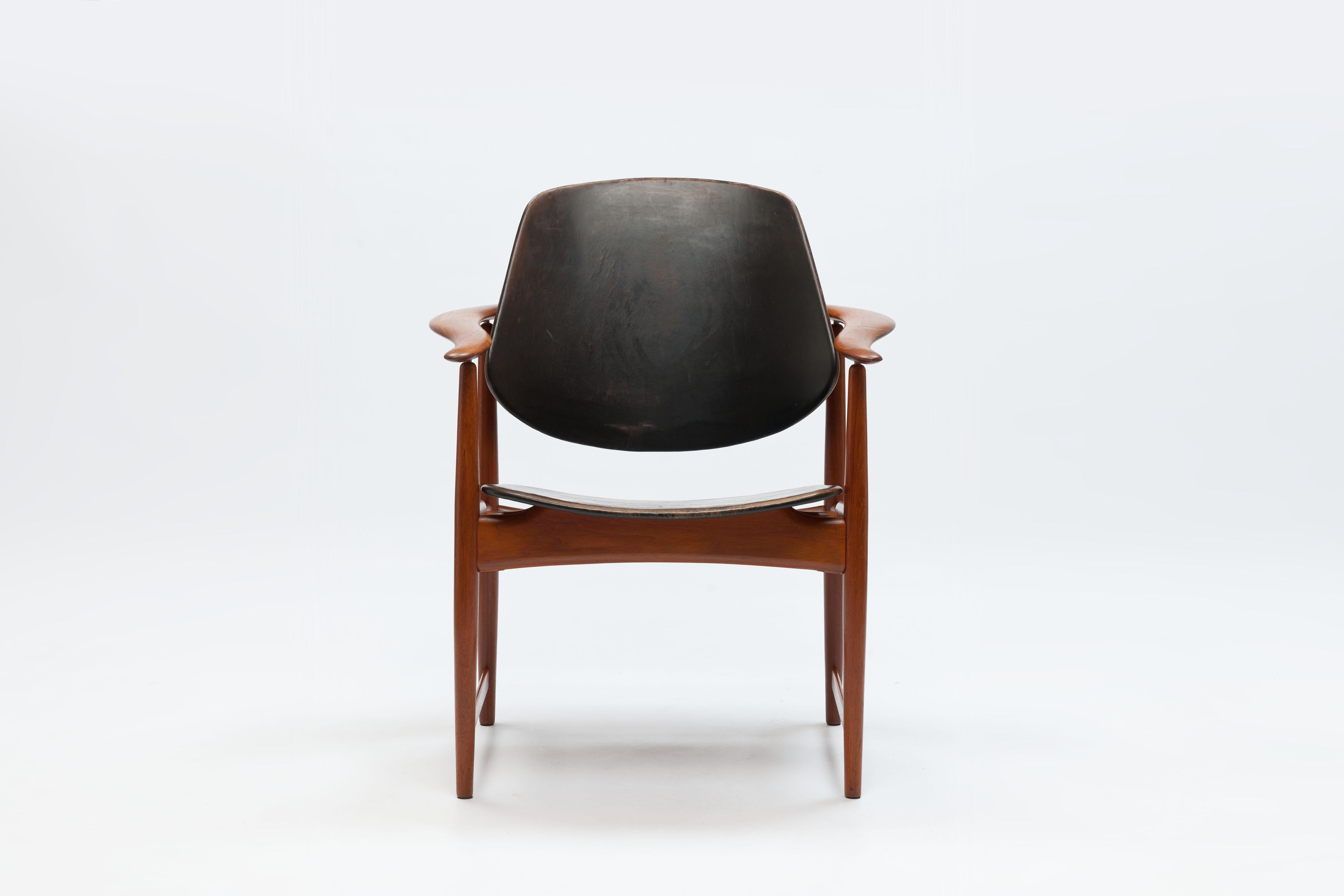 Beautiful larger chair with 'wraparound' armrests made of teak & leather designed by the Danish designer Arne Hovmand-Olsen (1919-1989) in 1960. 
Plywood was used for the wide backrest supported by a brass spacer that underlines the open character