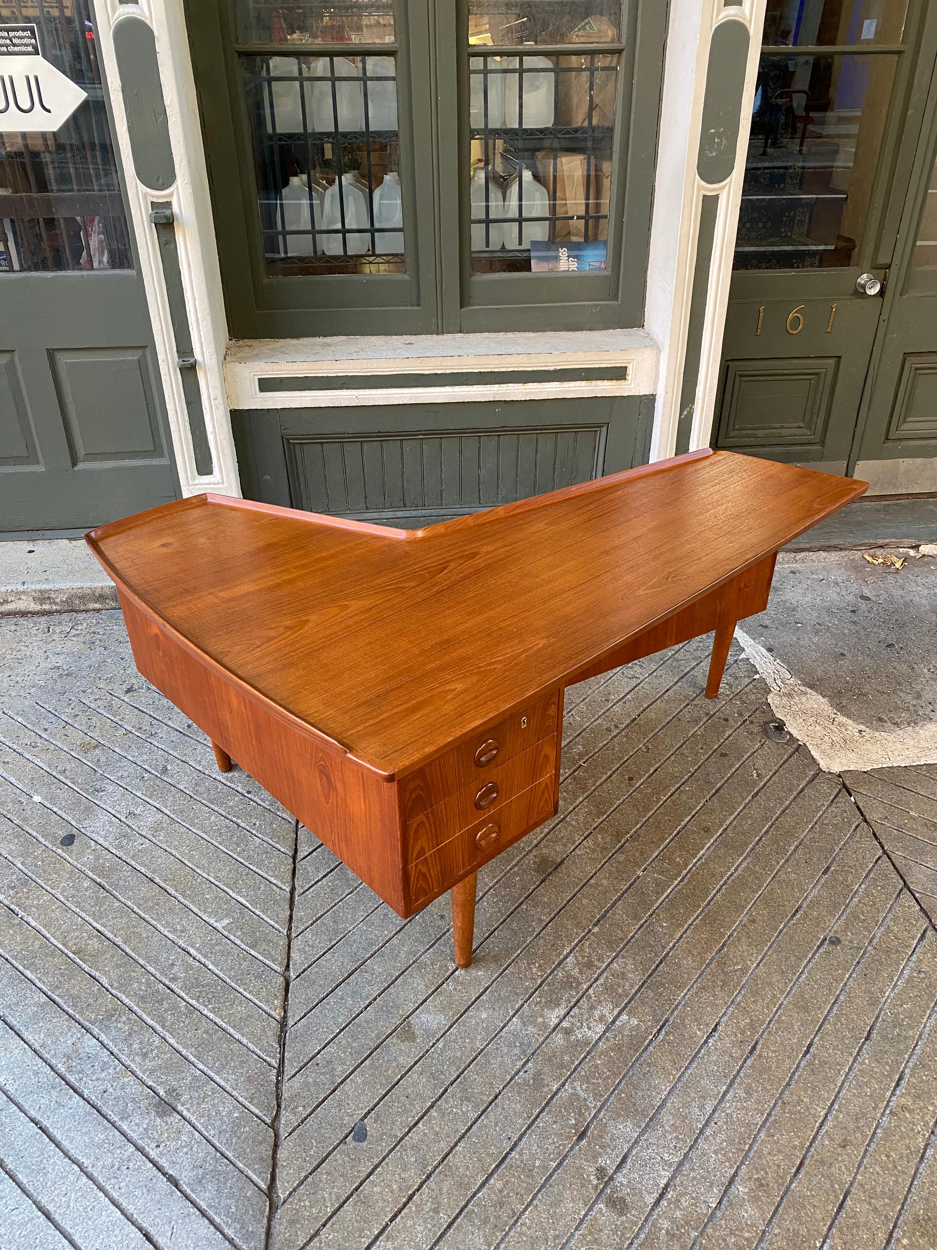 Arne Hovmand-Olsen teak boomerang desk, often attributed to Arne Vodder. Signed to underside of desk. Probably one of the most iconic Danish modern desks out there! Backside has original black glass sliding door and cabinet door opens to reveal a