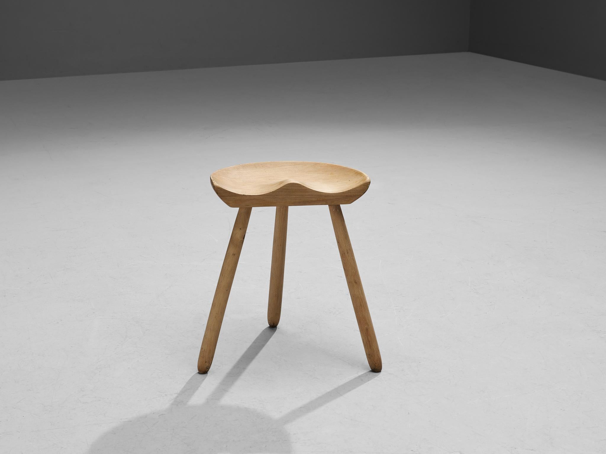 Arne Hovmand-Olsen, milking stool, beech, Denmark, 1950s. 

This Danish tripod stool by Arne Hovmand-Olsen contains a remarkable halved seat, which proves that it was inspired by the traditional milking stools. Despite the sturdy look of the design,