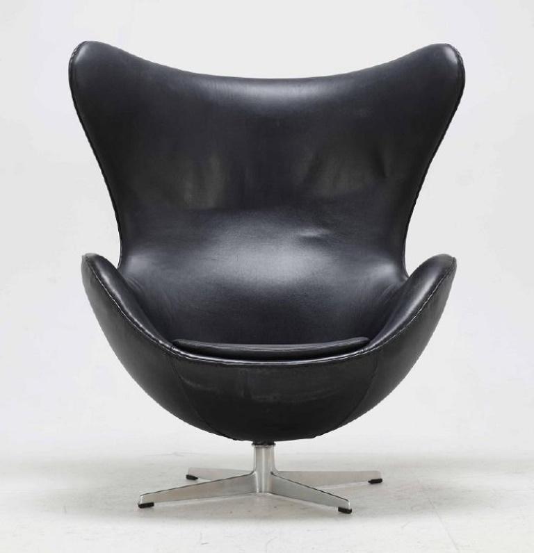 Arne Jacobsen (1902 - 1971). Stuhl „The Egg“, ikonisches Möbeldesign. 
Gepolstert mit schwarzem Leder, einer drehbaren Mittelsäule mit vierfachem Aluminiumfuß.
Entworfen in den Jahren 1958-59 als Teil der Gesamtausstattung des Hotels Royal