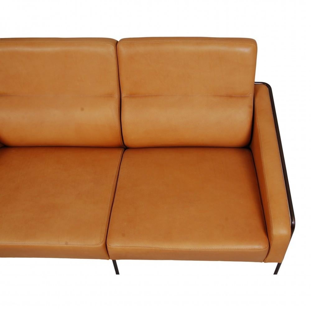 Arne Jacobsen 2-seater Airport sofa with cognac aniline leather and a brass frame. Allegedly made to order for SAS Royal Hotel in Copenhagen in the 60s. The sofa appears later reupholstered.