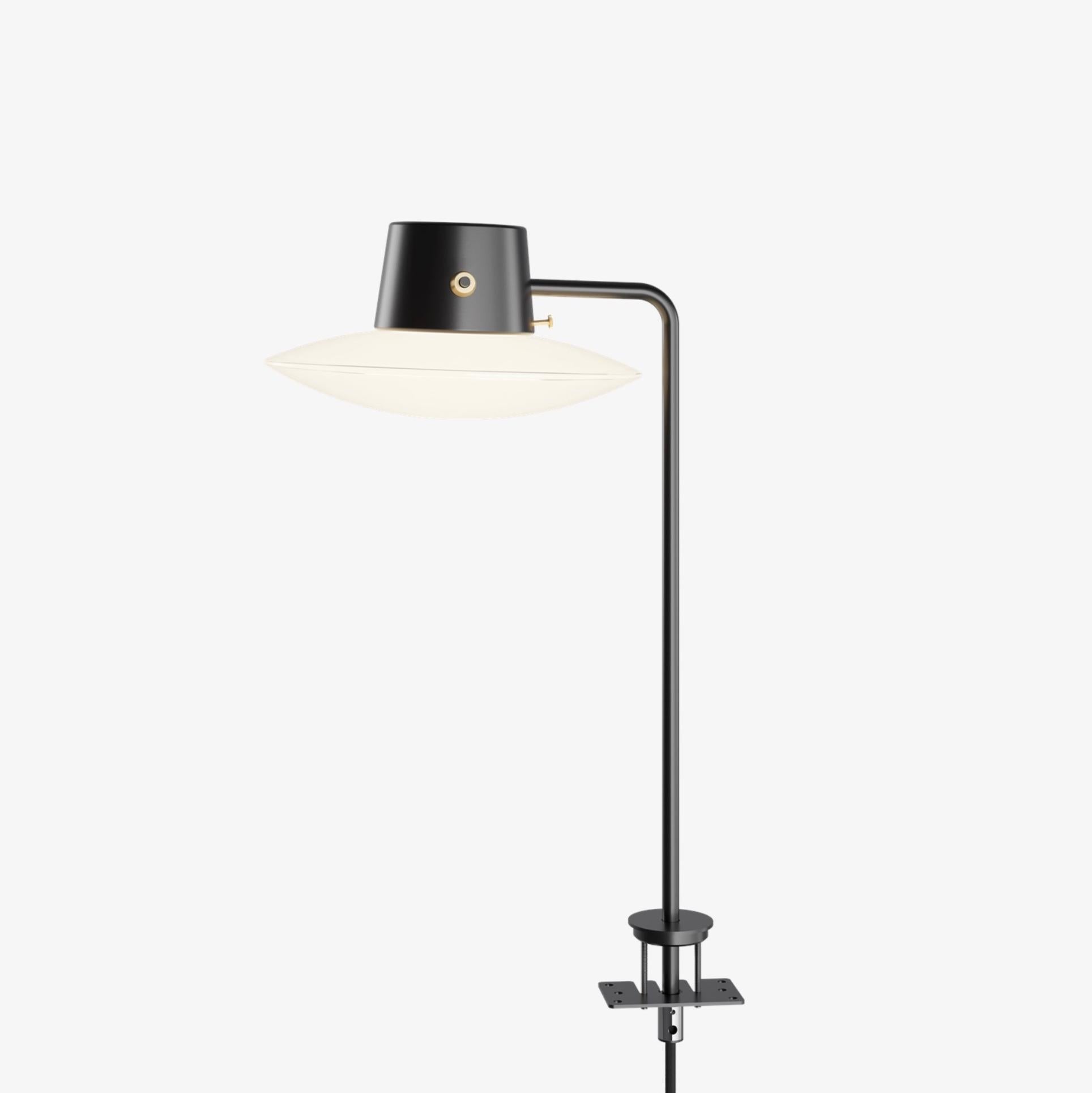 Arne Jacobsen AJ Oxford pin Tischleuchte 410mm in schwarz und opalin für Louis Poulsen. Entworfen 1963, derzeitige Produktion.

Die AJ Oxford Tischleuchte hat einen eleganten grafischen Ausdruck, der die Architektur des St. Catherine's College in