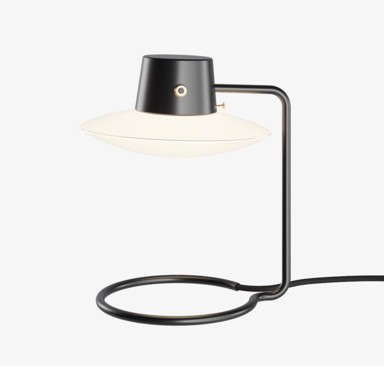 Lampe de table Arne Jacobsen AJ Oxford 280mm en noir et opaline pour Louis Poulsen. Conçue en 1963, production actuelle.

La lampe à poser AJ Oxford présente une expression graphique épurée, qui reflète l'architecture du St Catherine's College, à