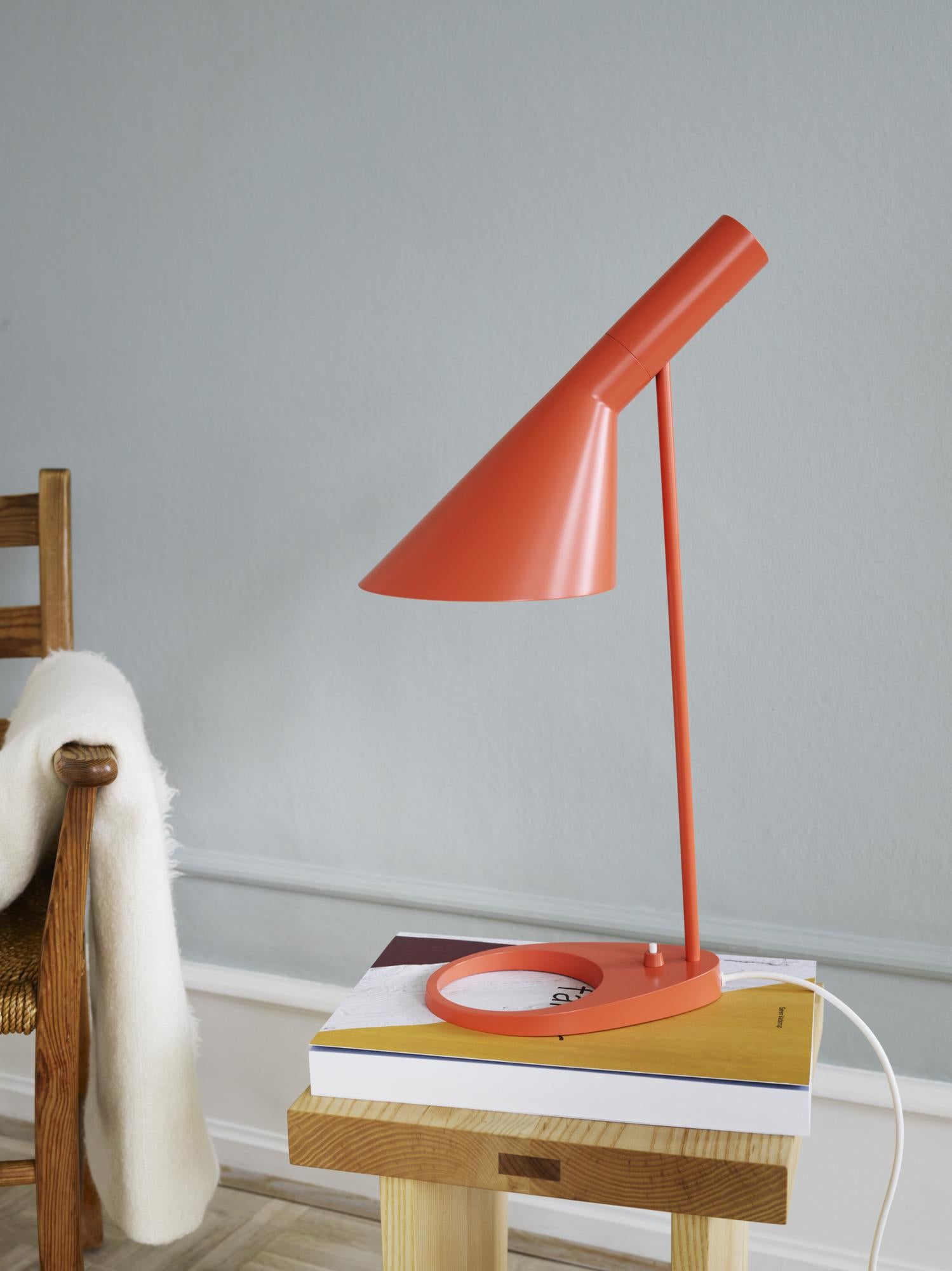 Arne Jacobsen AJ table lamp in electric orange for Louis Poulsen.

The AJ series was part of the lighting collection renowned Danish designer Arne Jacobsen created for the original SAS Royal Hotel in 1957. Today, his furniture and lighting designs