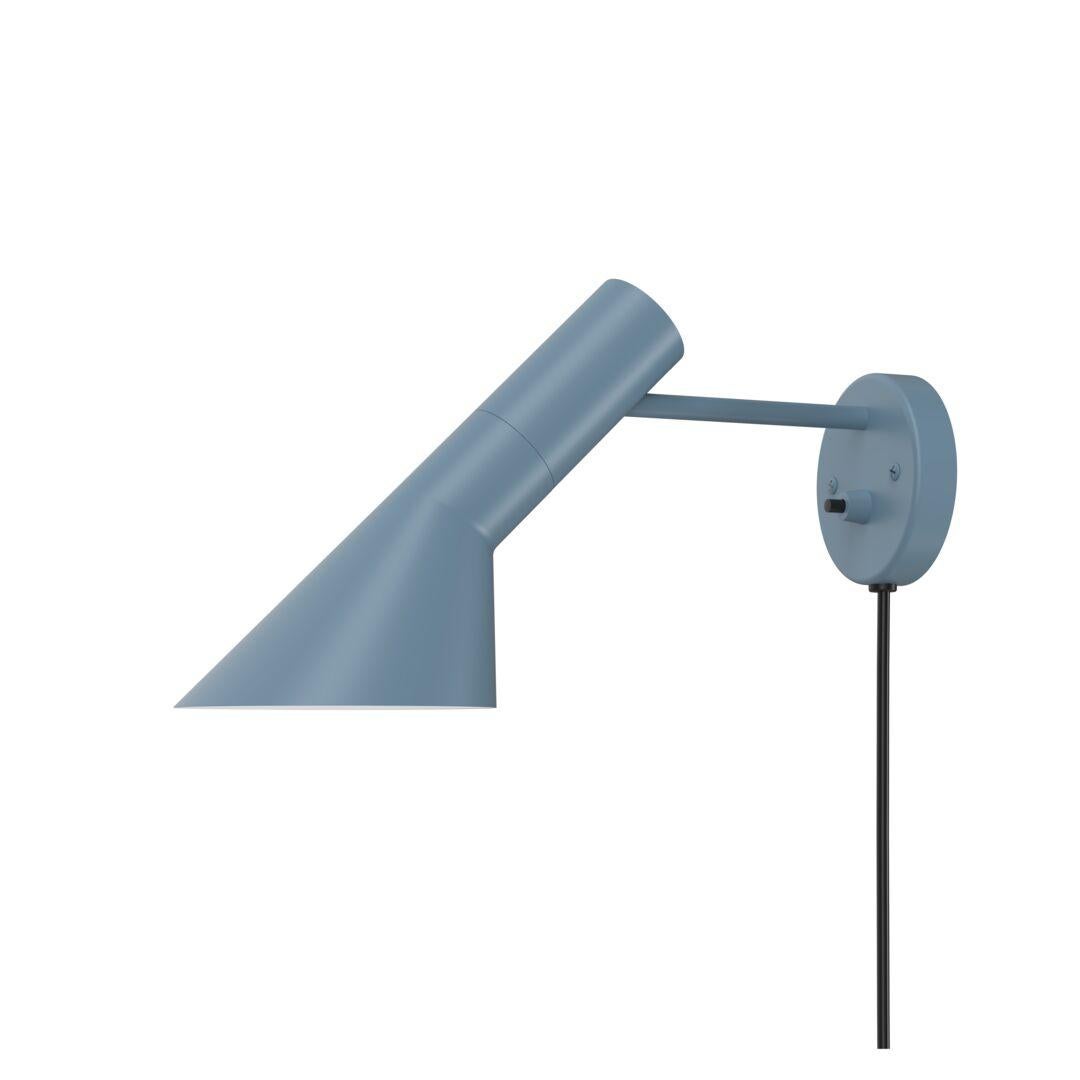 Arne Jacobsen AJ wall light for Louis Poulsen in dusty blue. 
The AJ series was part of the lighting Jacobsen designed for the original SAS Royal Hotel. Today, his furniture and lighting designs are sought after by collectors worldwide. Executed in