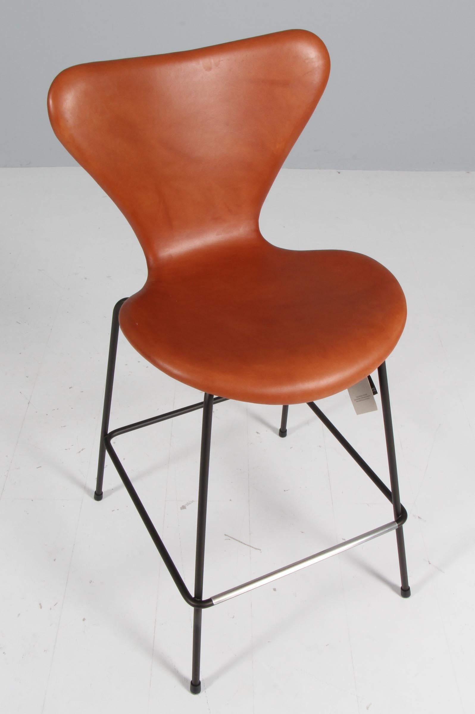 Arne Jacobsen bar chair with shell of cognac aniline leather

Base of dark brown powder coated steel.

Model 3187 Syveren, made by Fritz Hansen.