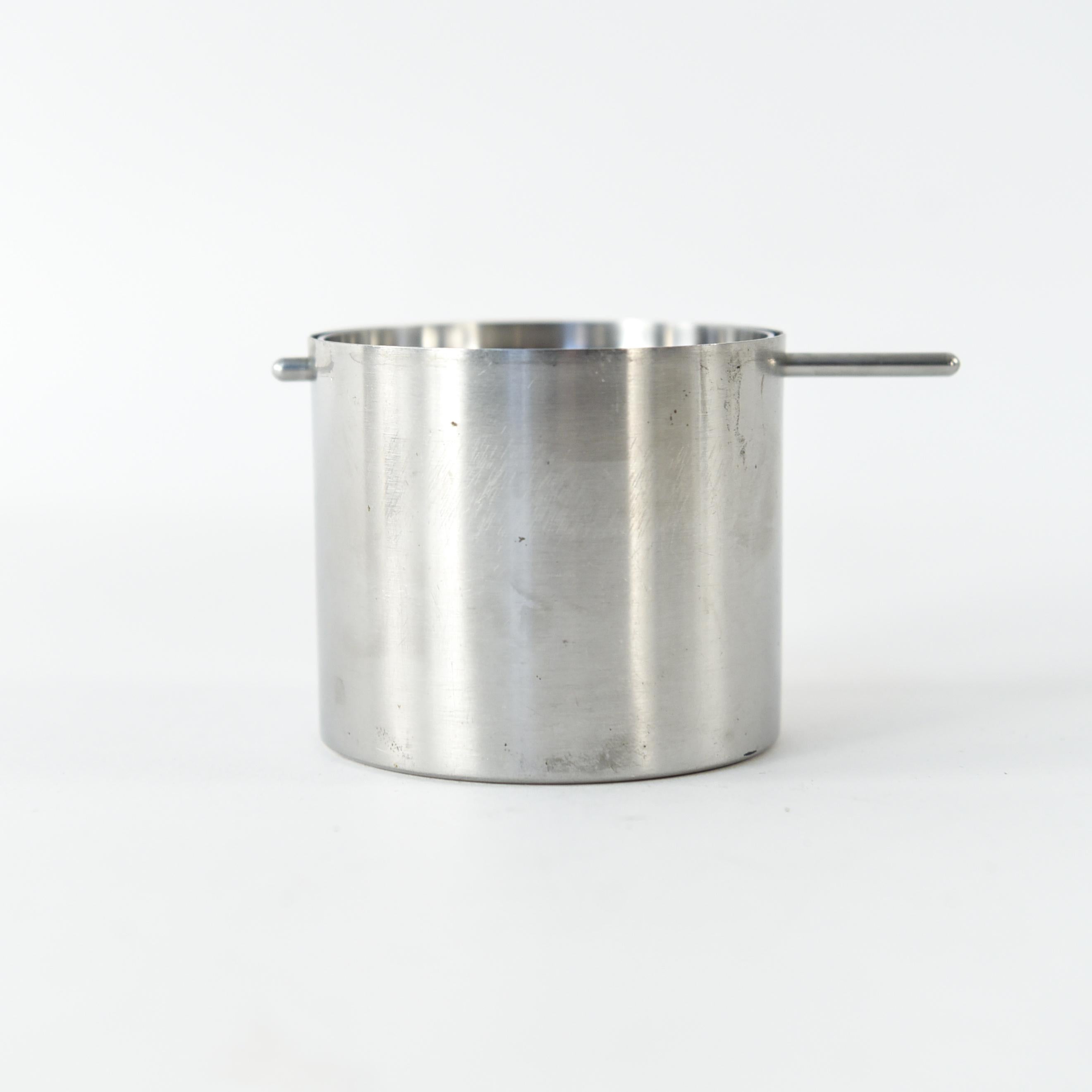 These ashtrays are an iconic form by Danish designer Arne Jacobsen for Stelton. From the Cylinda Line, 1967. They feature a revolving top, with a sleek midcentury chrome look. Two available. Marked Stelton underneath.