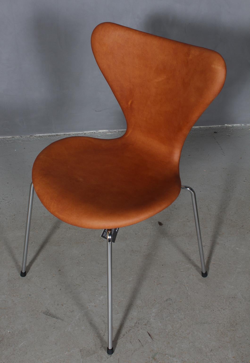 Arne Jacobsen dining chair new upholstered with vintage tan aniline leather.

Base of chrome steel tube.

Model 3107 Syveren, made by Fritz Hansen.

New shell and base reupholsterd, with certificate.