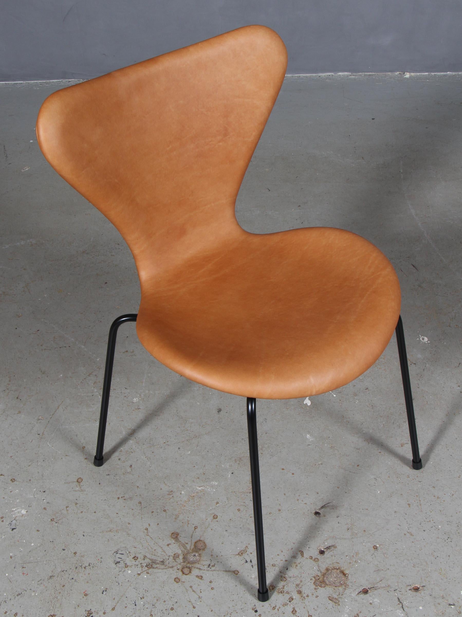 Chaise de salle à manger Arne Jacobsen nouvellement tapissée de cuir aniline vintage cognac.

Base en tube d'acier revêtu de poudre.

Modèle 3107 Syveren, fabriqué par Fritz Hansen.