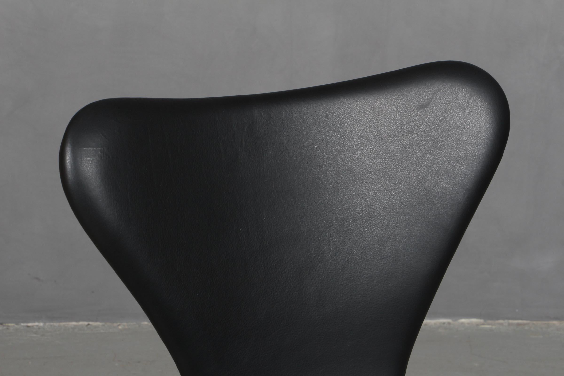 Arne Jacobsen dining chair new upholstered with black aniline leather.

Base of powder coated steel tube.

Model 3107 Syveren, made by Fritz Hansen.