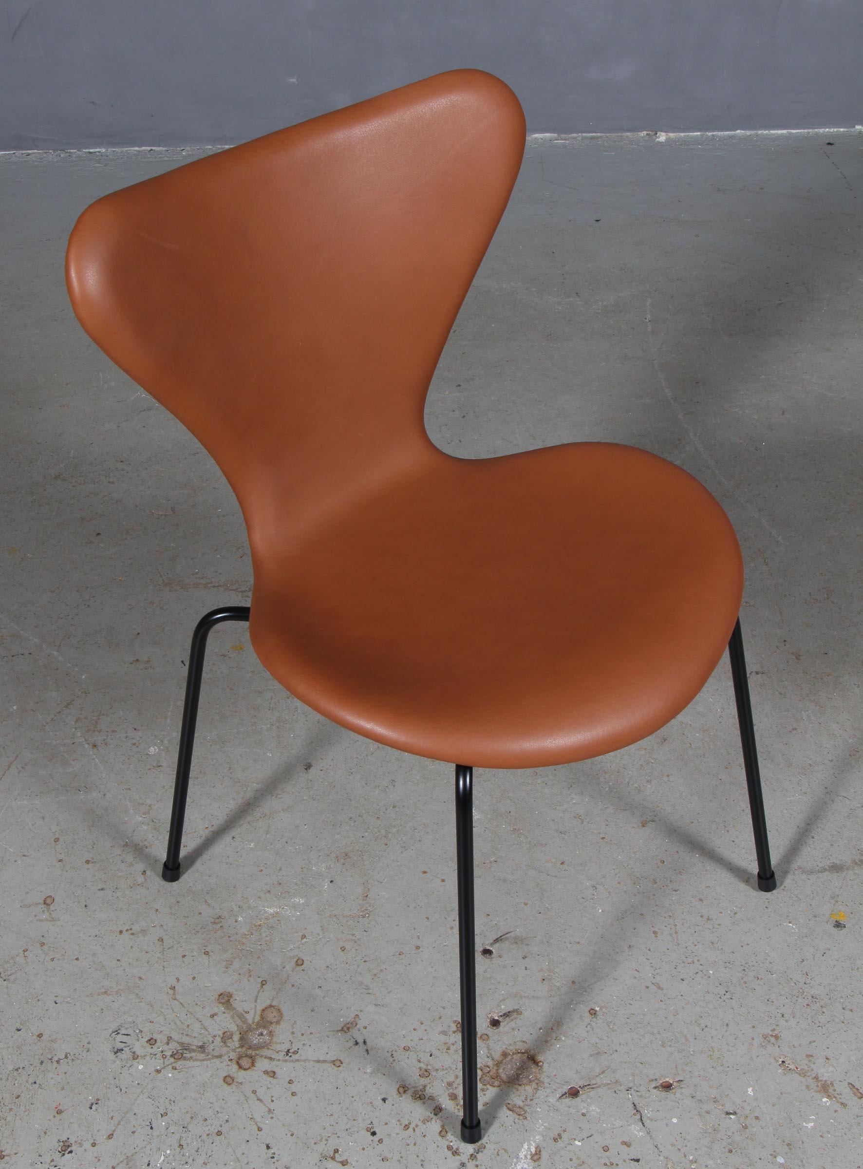 Arne Jacobsen dining chair new upholstered with cognac pure aniline leather.

Base of powder coated steel tube.

Model 3107 Syveren, made by Fritz Hansen.