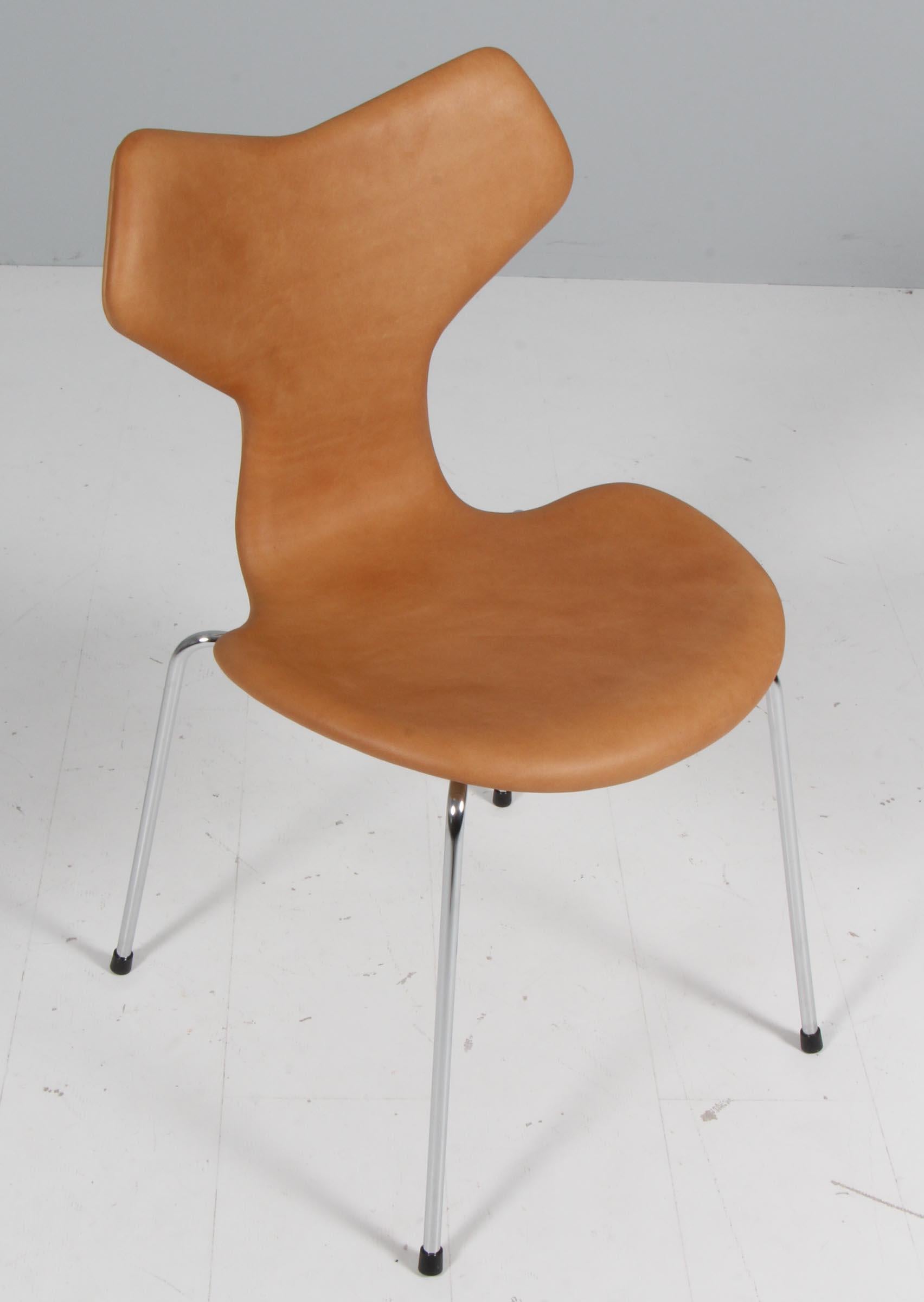 Arne Jacobsen dining chair new upholstered with vintage tan aniline leather.

Base of chrome steel tube.

Model 3130 Grand Prix, made by Fritz Hansen.