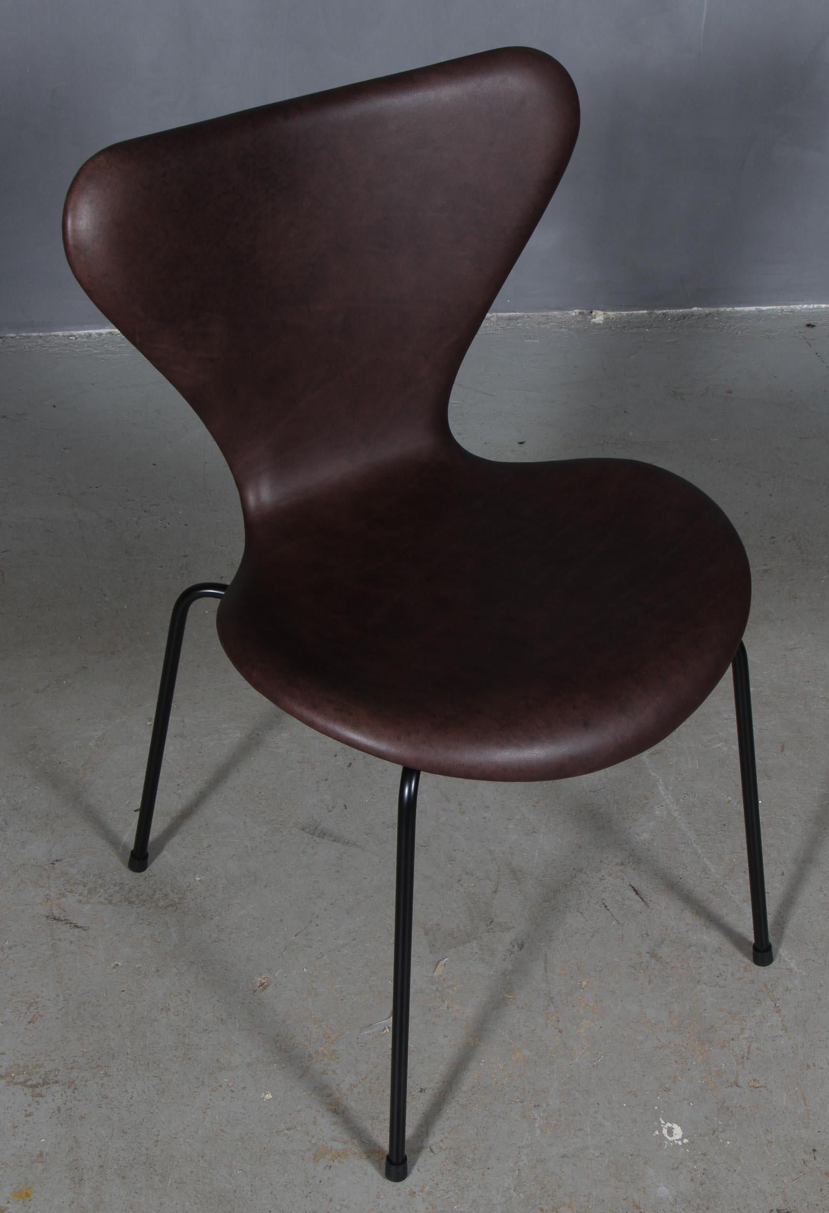 Arne Jacobsen dining chair new upholstered with Mokka aniline leather.

Base of powder coated steel tube.

Model 3107 Syveren, made by Fritz Hansen.