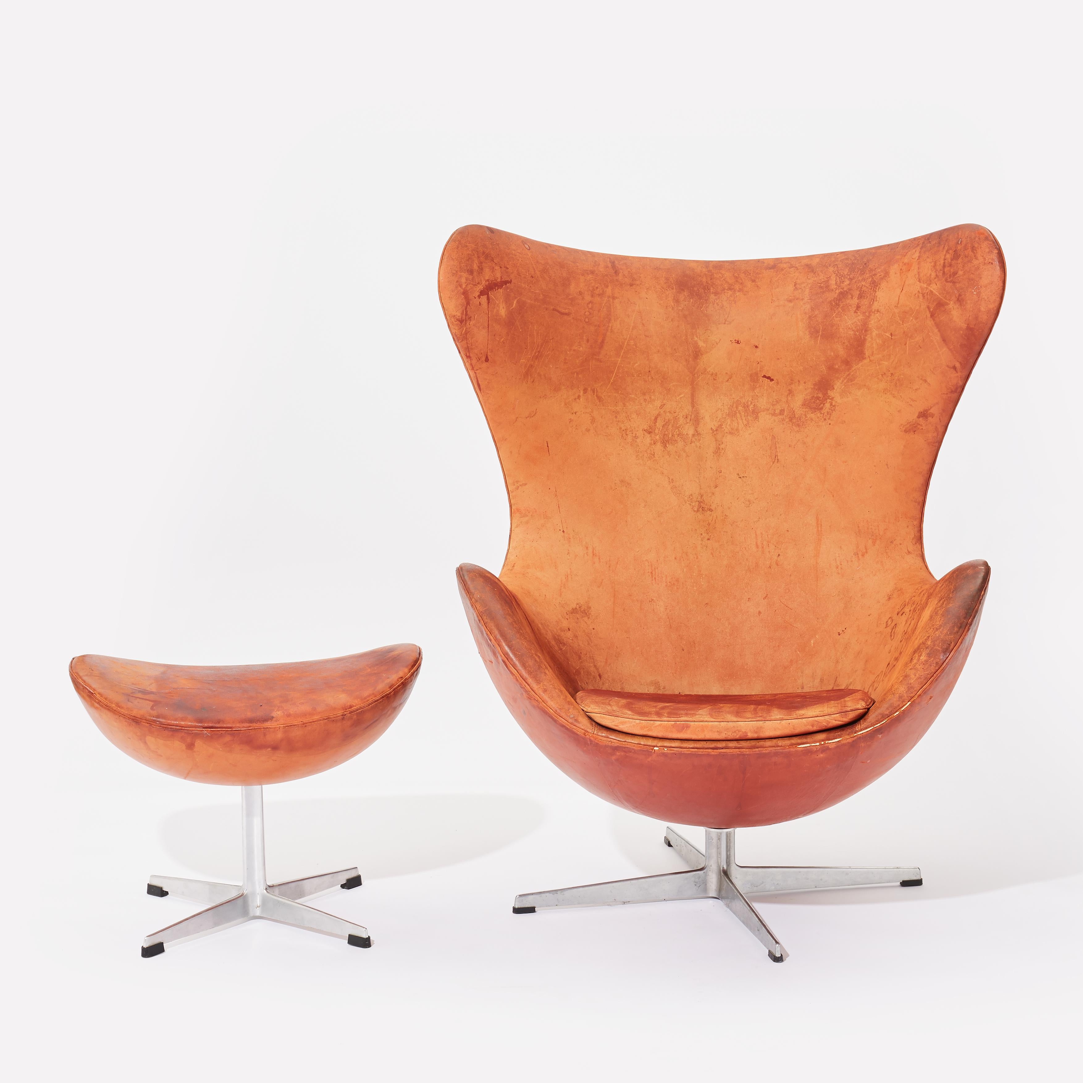 Early easy Egg chair model 3316 and ottoman designed by Arne Jacobsen and produced by Fritz Hansen in Denmark in 1958. Vintage original upholstery with patinated light brown leather. Signed by Fritz Hansen.