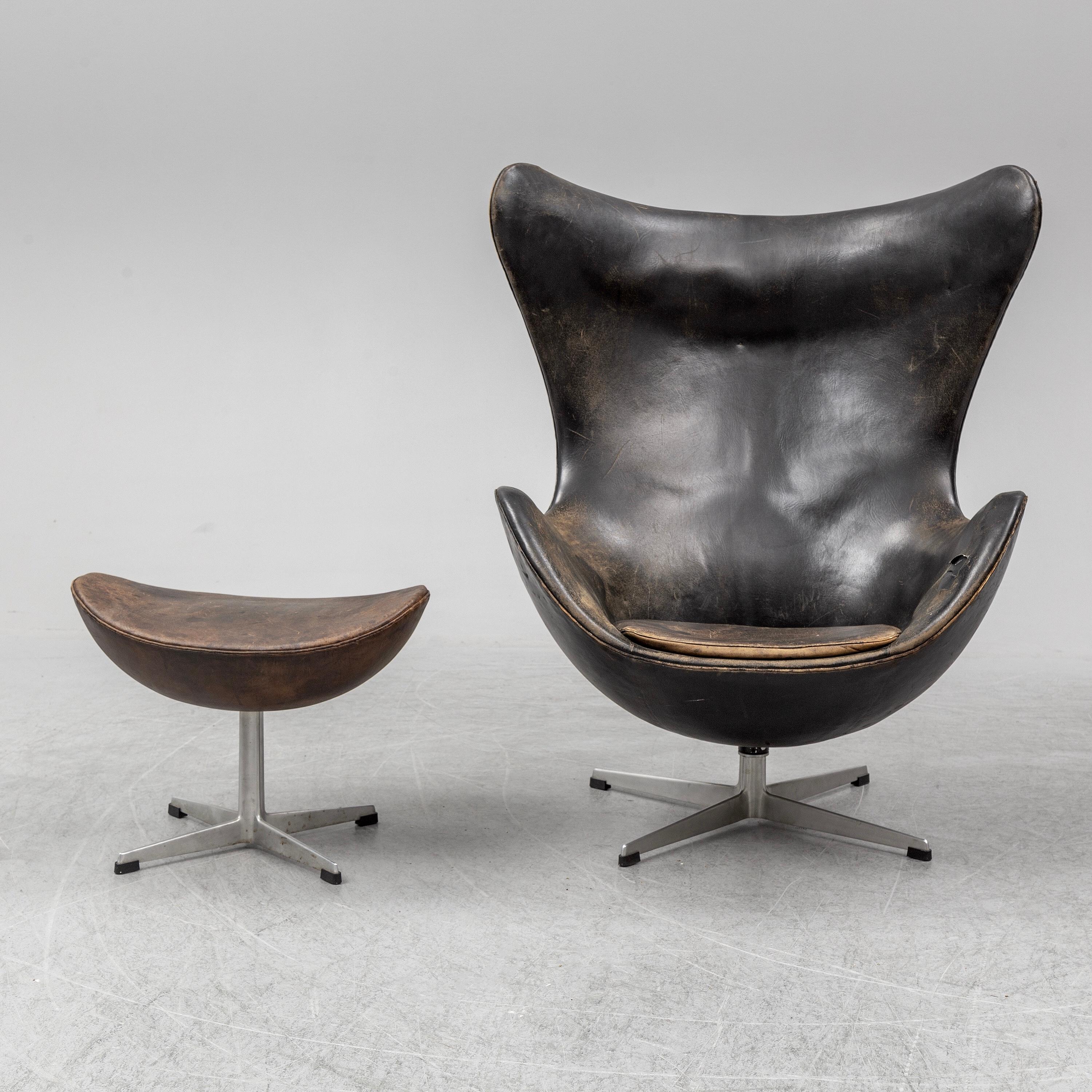 Early easy egg chair model 3316 and ottoman designed by Arne Jacobsen and produced by Fritz Hansen in Denmark in 1958. Vintage original upholstery with patinated dark brown leather. Signed by Fritz Hansen.