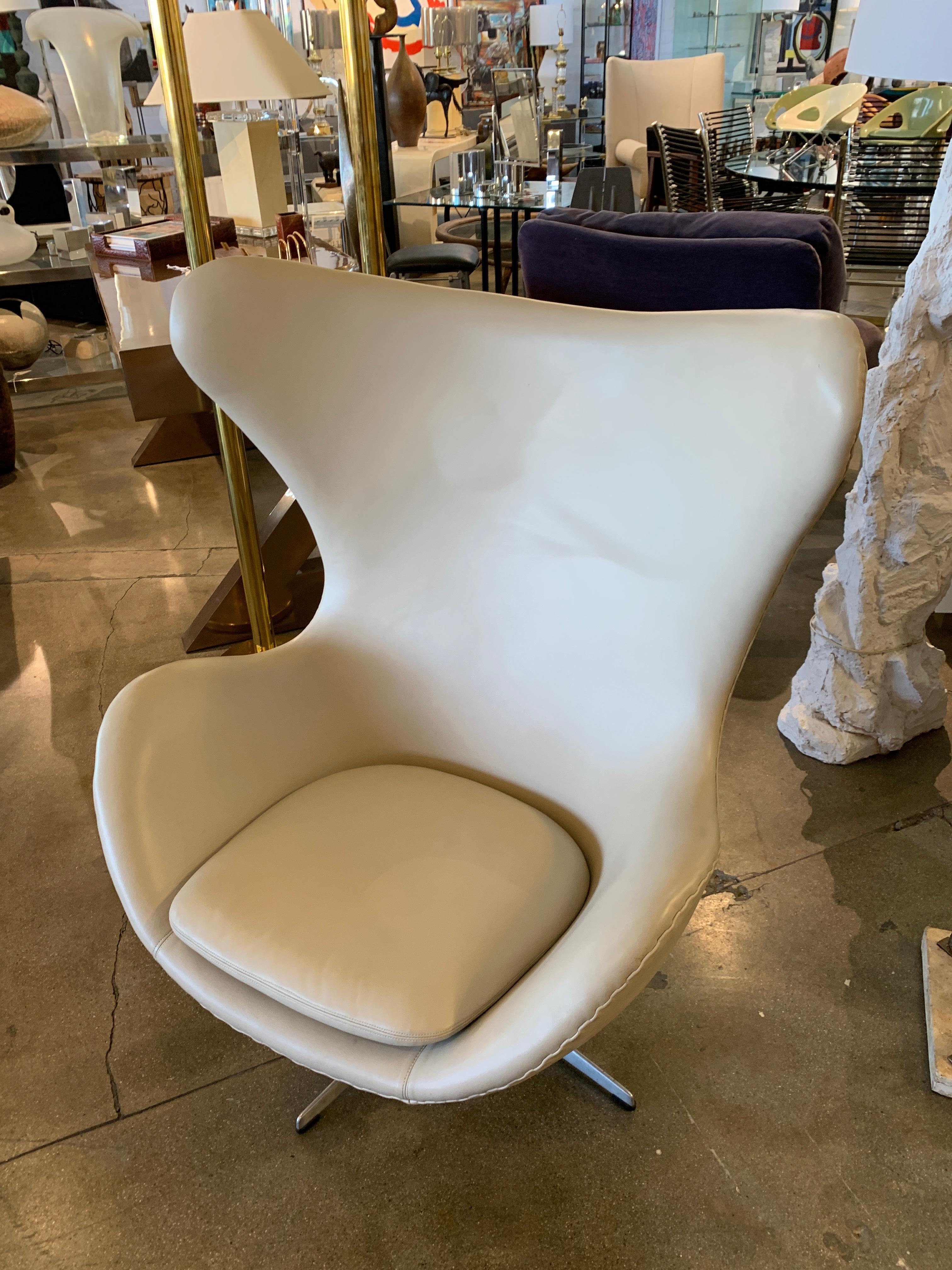 A leather Egg chair designed by Arne Jacobsen and produced by Fritz Hansen. The base bears a Fritz Hansen sticker. These have been redone at some point in a beige tan leather. The chair is in good condition with some marks to the metal base and some