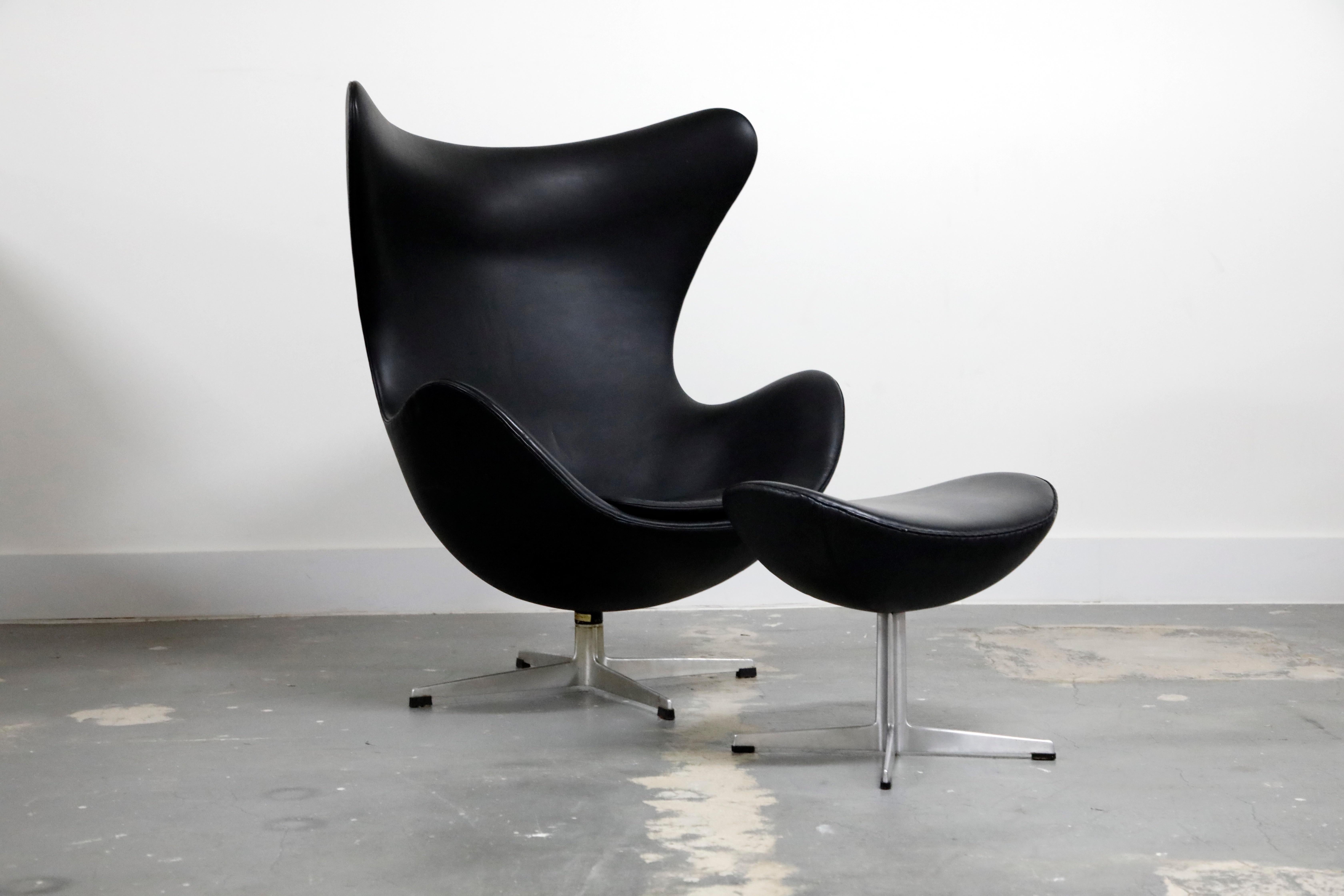 This iconic black leather egg chair by Arne Jacobsen is an all-original 1965 production by Fritz Hansen and signed underneath both pieces with the original date-stamped foil labels. The Classic and timeless (original) black leather is one of the