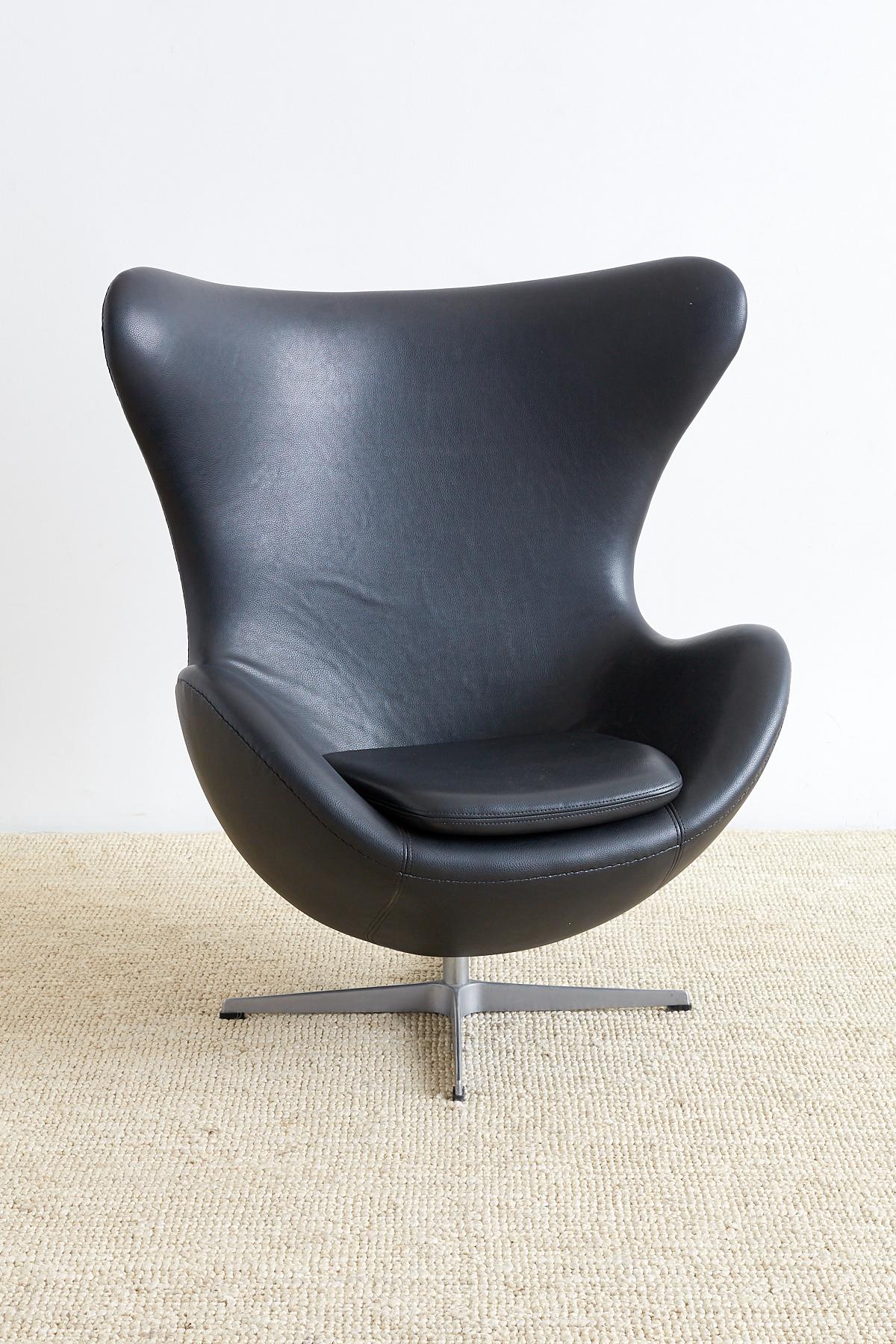 Authentic Arne Jacobsen for Fritz Hansen black egg chair originally designed for the SAS hotel in Copenhagen. Features a hand-stitched faux leather upholstery that has replaced the original black leather. Supported by a one piece cast aluminum