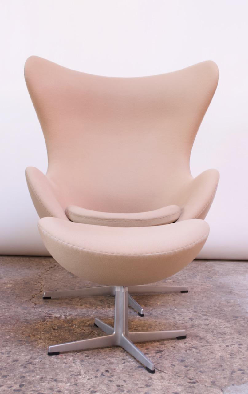 Originally designed in 1958 for the Royal Hotel in Copenhagen, this 1999 authentic production Arne Jacobsen egg chair and corresponding ottoman were manufactured by Fritz Hansen and distributed in the United States by Knoll.
Biomorphic design with