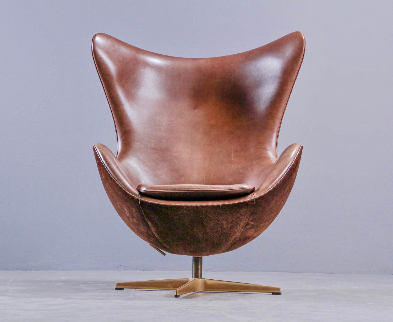 Arne Jacobsen. 'The Golden Egg', Model 3316. Original upholstered in chocolate-brown leather on the front and chocolate-brown suede on the back. Four-star base in solid hand-polished bronze. Designed in 1958. Produced by Fritz Hansen in a limited