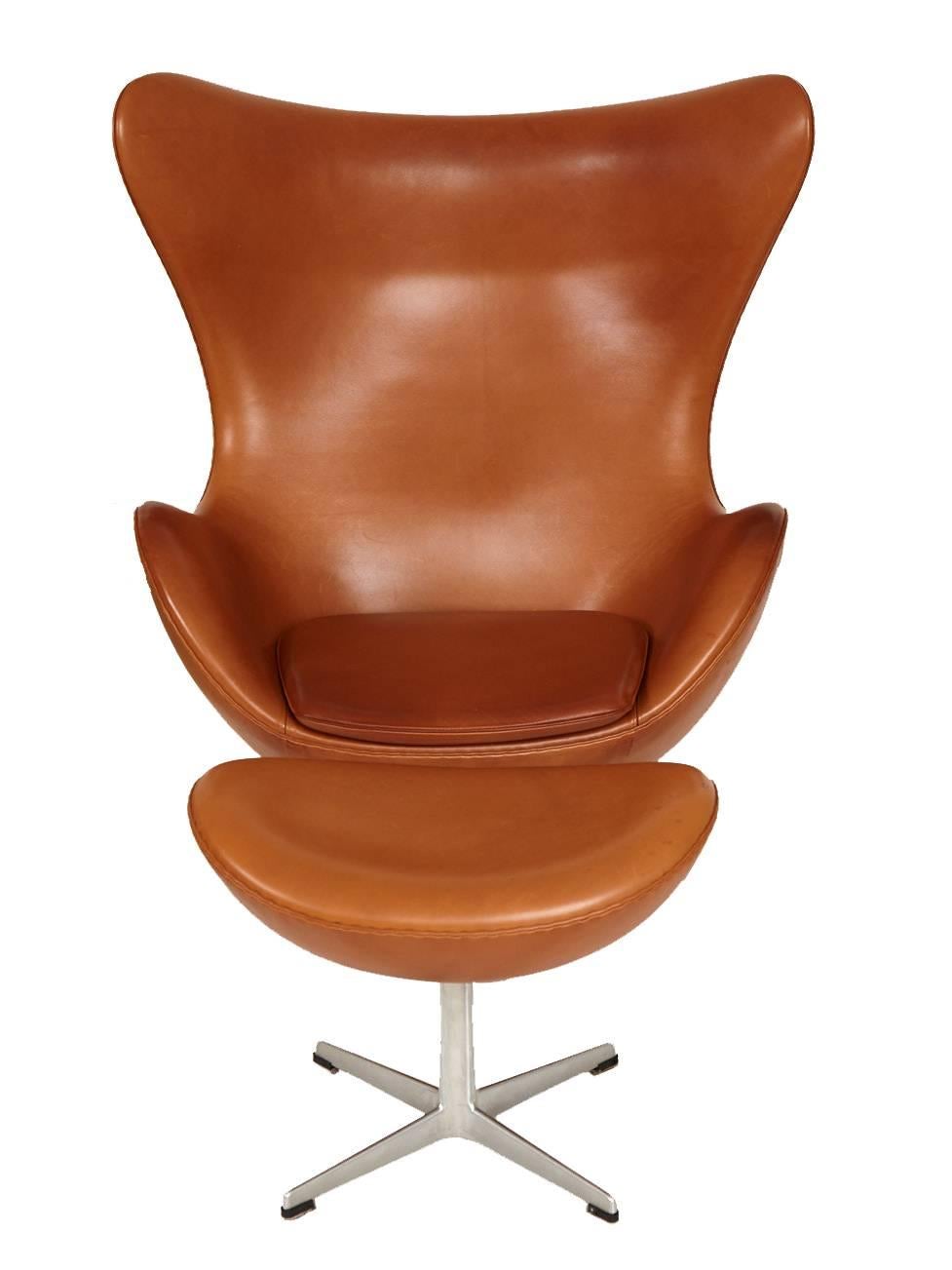 Arne Jacobsen leather Egg chair and ottoman circa 1990s in beautiful lightly patinated condition complete with Tilt Swivel mechanism for Fritz Hansen.

In 1958, Arne Jacobsen designed the Egg for the lobby and reception areas of the Royal Hotel in