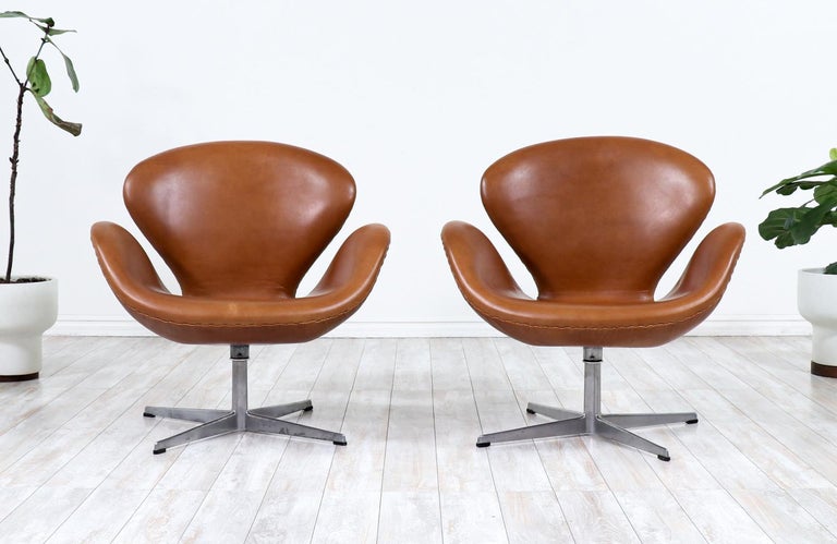 Iconic Swan chairs designed by Arne Jacobsen for Fritz Hansen in Denmark circa 1950's. Originally designed for the SAS Royal Hotel in Copenhagen, this pair of chairs by the Danish design pioneer, Arne Jacobsen, have become iconic and representative