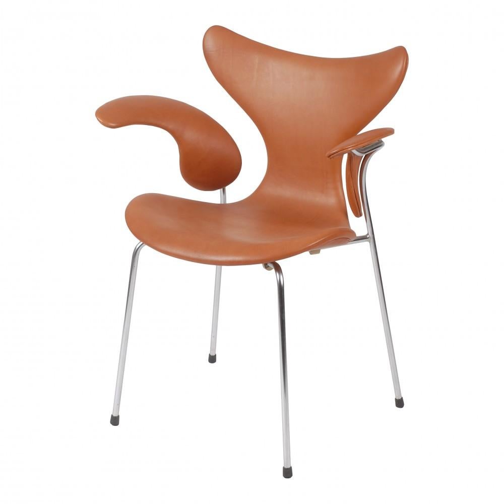These Lily chairs are used and newly upholstered with cognac aniline leather and fitted with new foam cushions. The chairs have firm backs and the frames are polished with no rust. The chairs are original and manufactured by Fritz Hansen. The