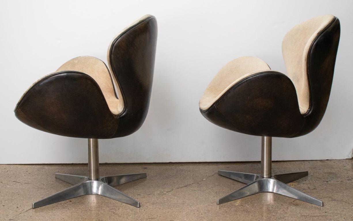 Pair of Arne Jacobsen (Danish, 1902-1971) Mid-Century Modern Swan Chairs, upholstered in gray leather and mohair on chrome swivel bases, one on casters. 

Dealer: ABAB