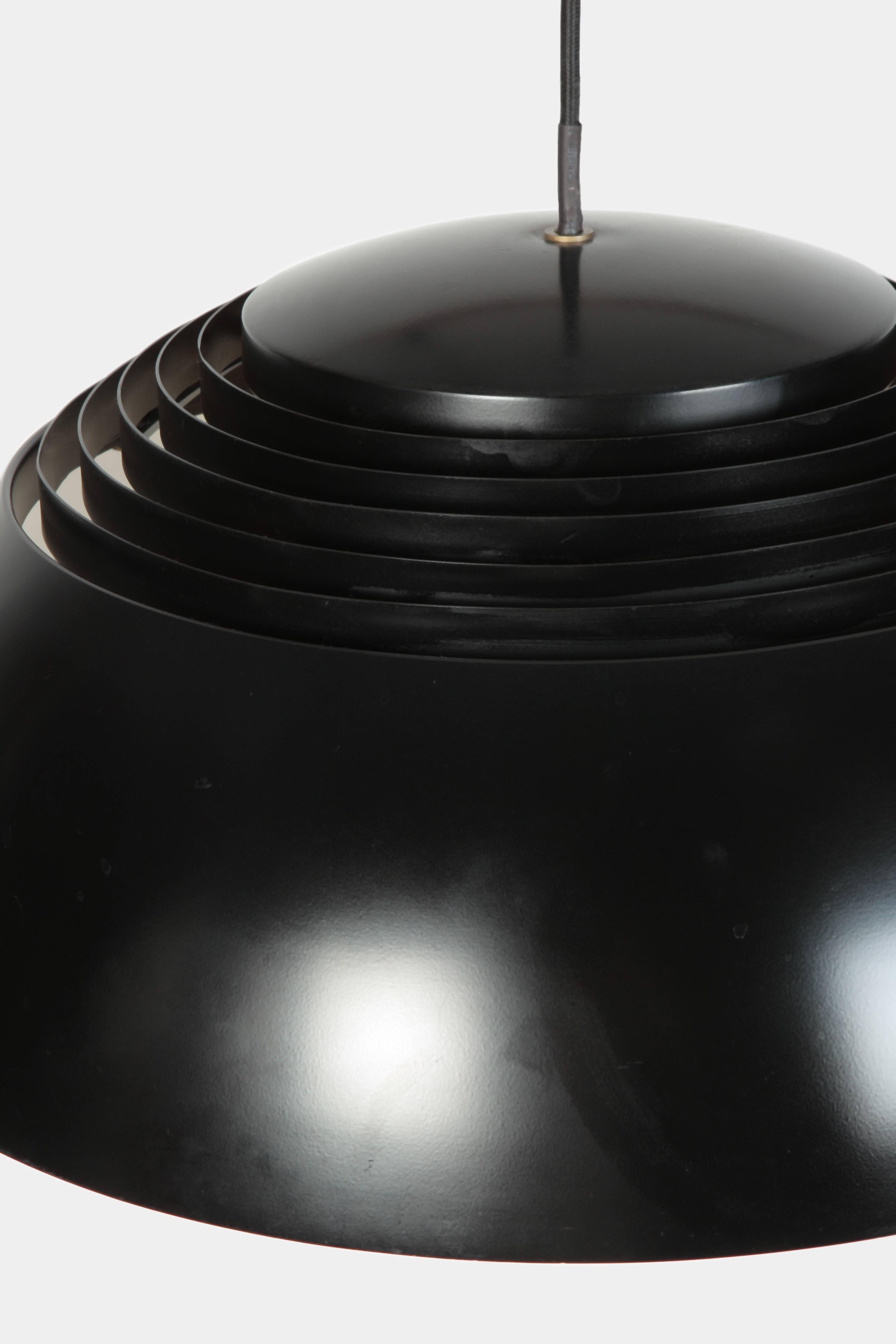 Arne Jacobsen pendant manufactured by Louis Poulsen in the 1960s in Denmark. Black lacquered metal shade. A white lacquered inner shade diffuses the light upwards and downwards, it creates also a beautiful light effect on the ceiling. It needs