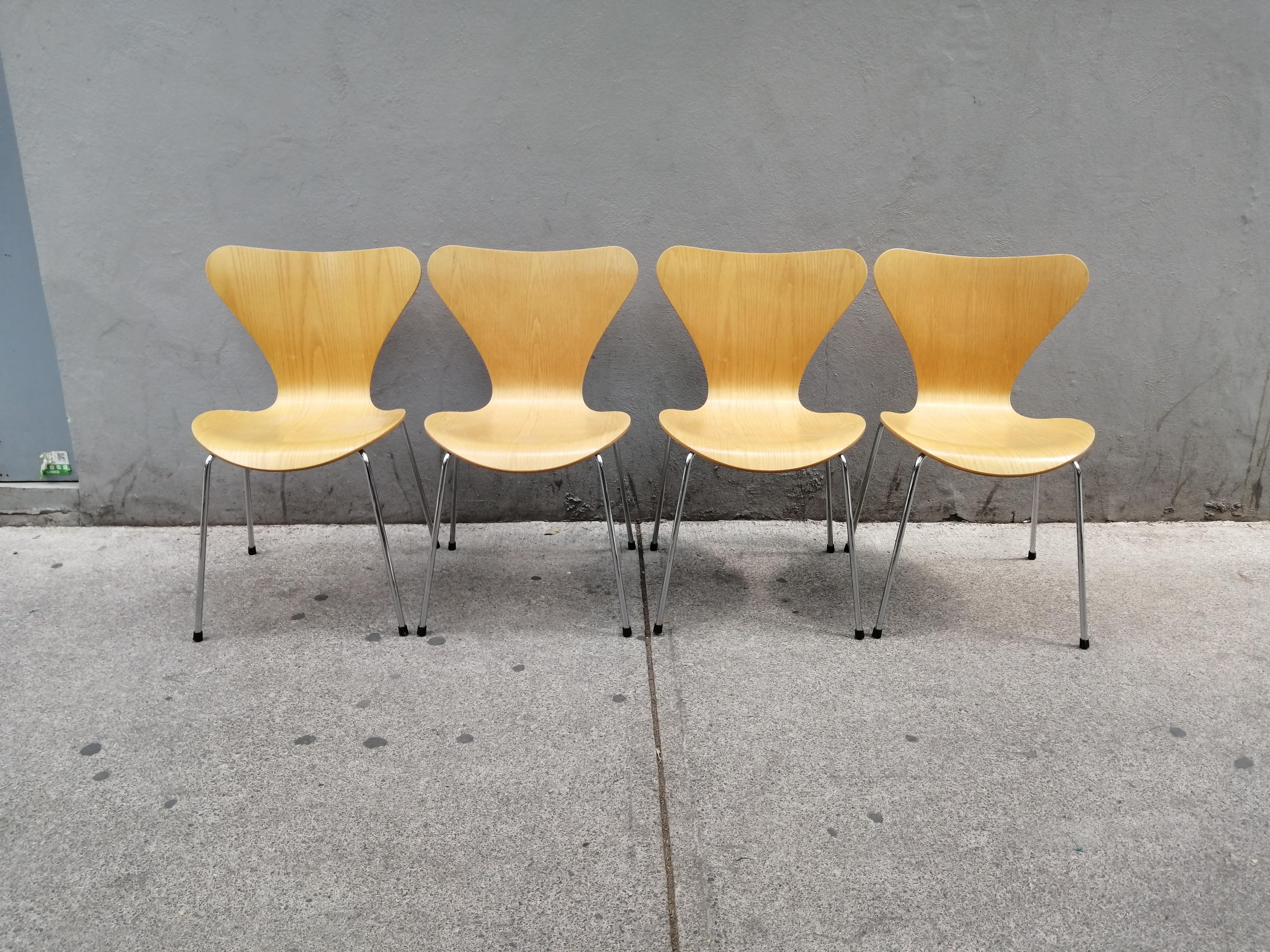 A set of 4 ash plywood and steel model 3107 (number 7) chairs by Arne Jacobsen. These chairs were manufactured in 1999 by Fritz Hansen and distributed by Knoll Studio. The chair's wood structures show lovely veneer grains.

We currently have other