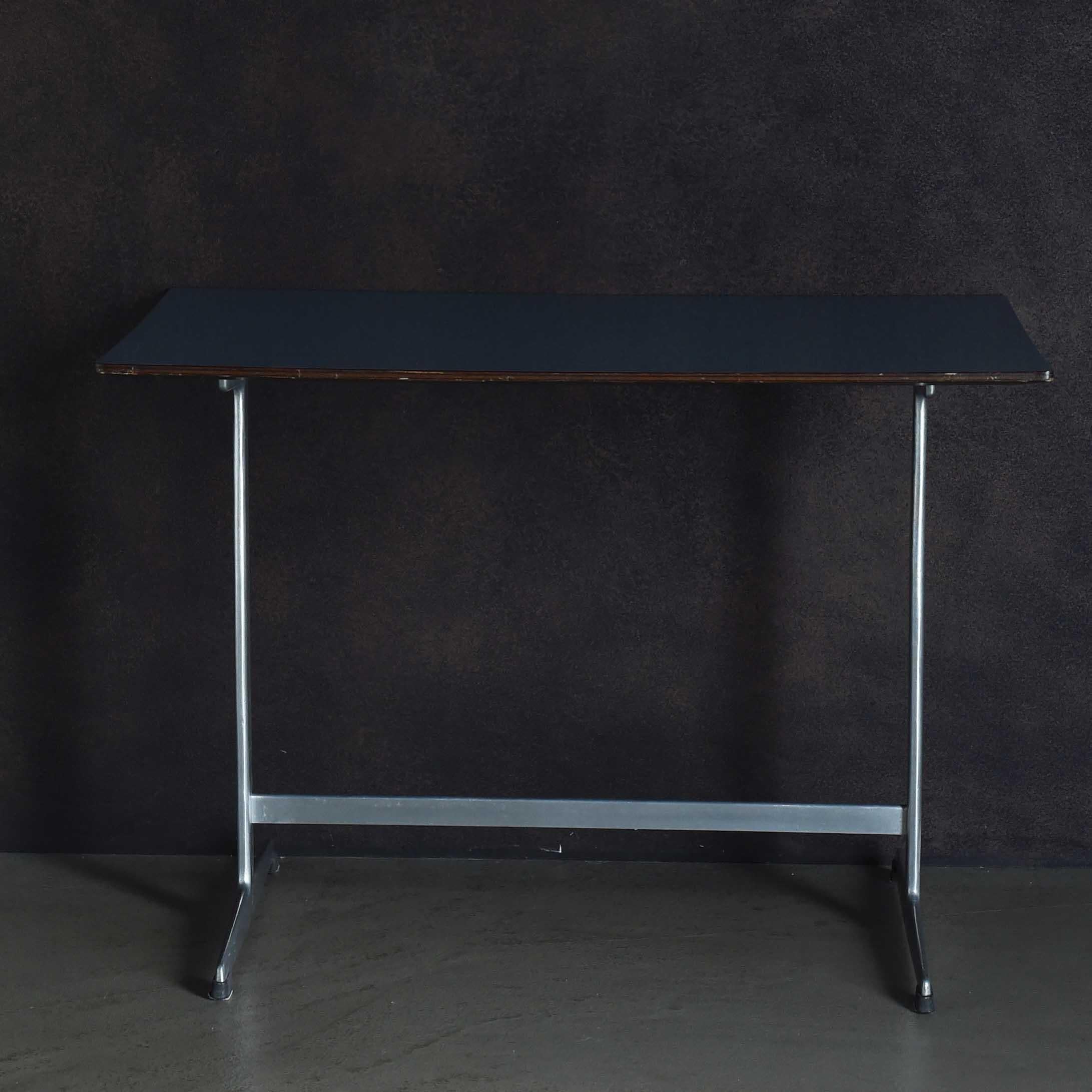 The Shaker Board (table) has a sleek image, possibly due to its steel legs. This center table, with a rectangular top and a Shaker base, was designed by Arne Jacobsen in collaboration with Poul Henningsen and Bruno Mathsson as part of a series of
