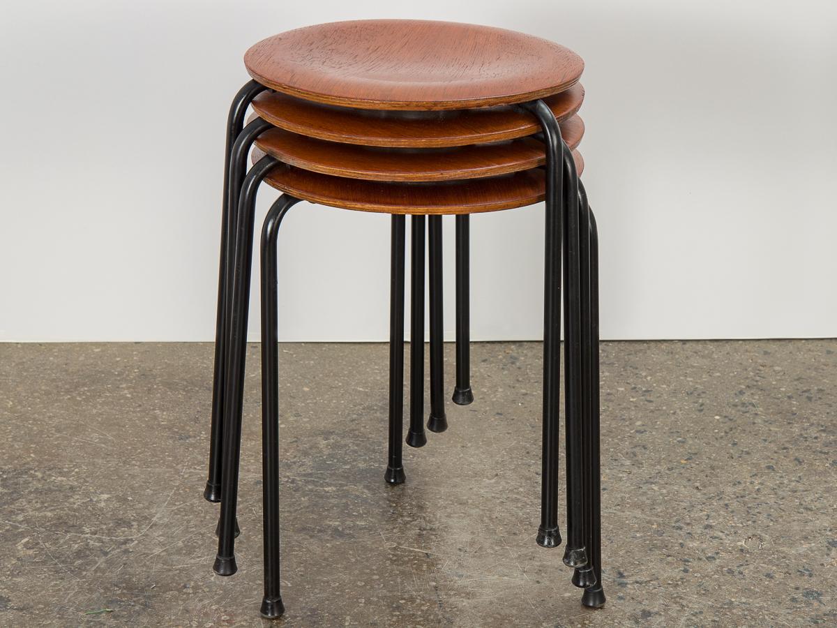 Set of Danish modern teak dot stools designed by Arne Jacobsen for Fritz Hansen. A minimal design with endless uses. Gleaming teak circle top supported by a sturdy black enamel base. Teak wood surface has nice patina, with clean edges all around.