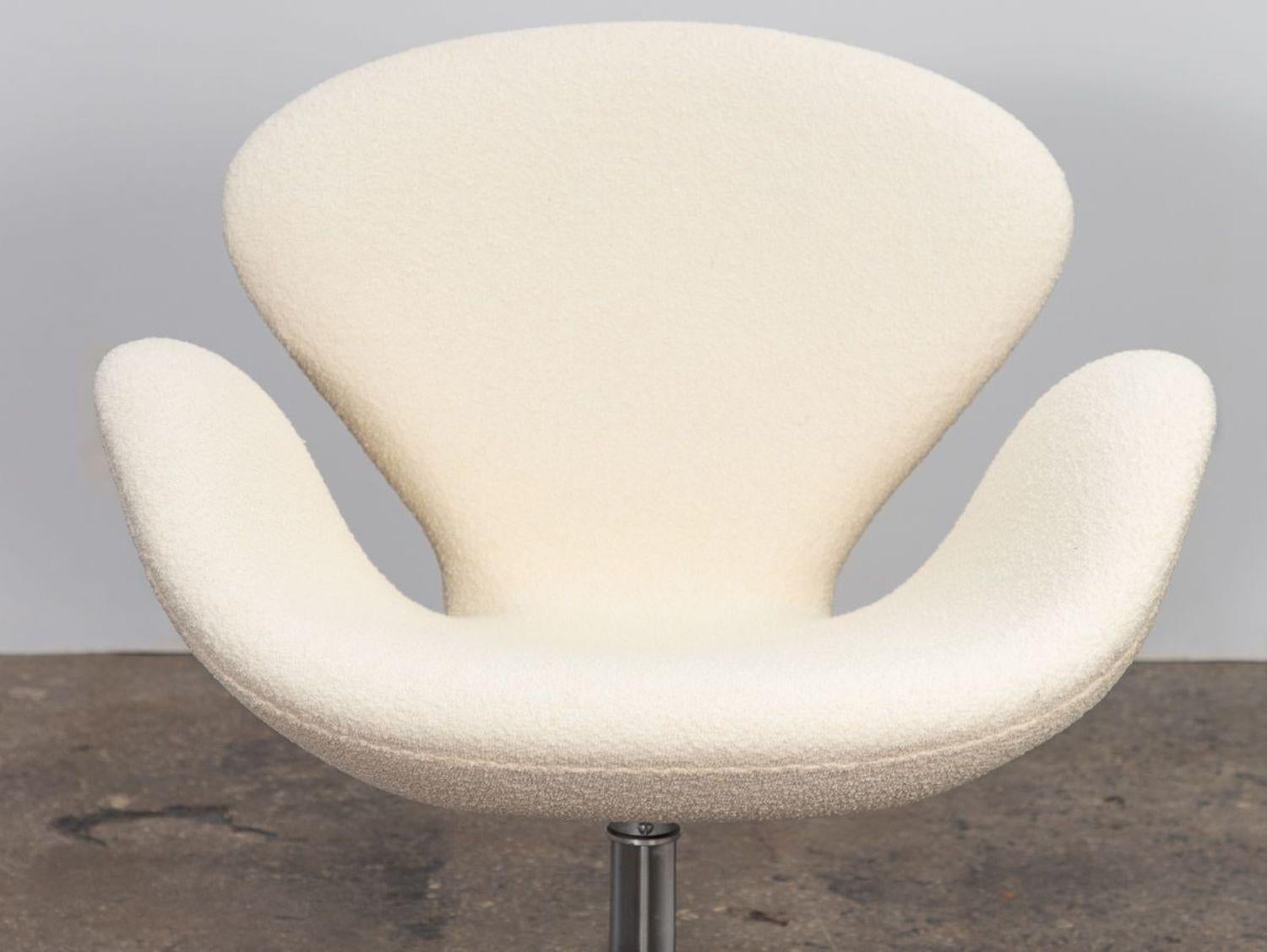 Iconic Swan chair designed by Arne Jacobsen for Fritz Hansen. Attractive, ergonomic curves designed to sheathe its sitter and follow resting limbs. Sits on brushed aluminum swiveling four-star base for additional height. Newly upholstered in soft