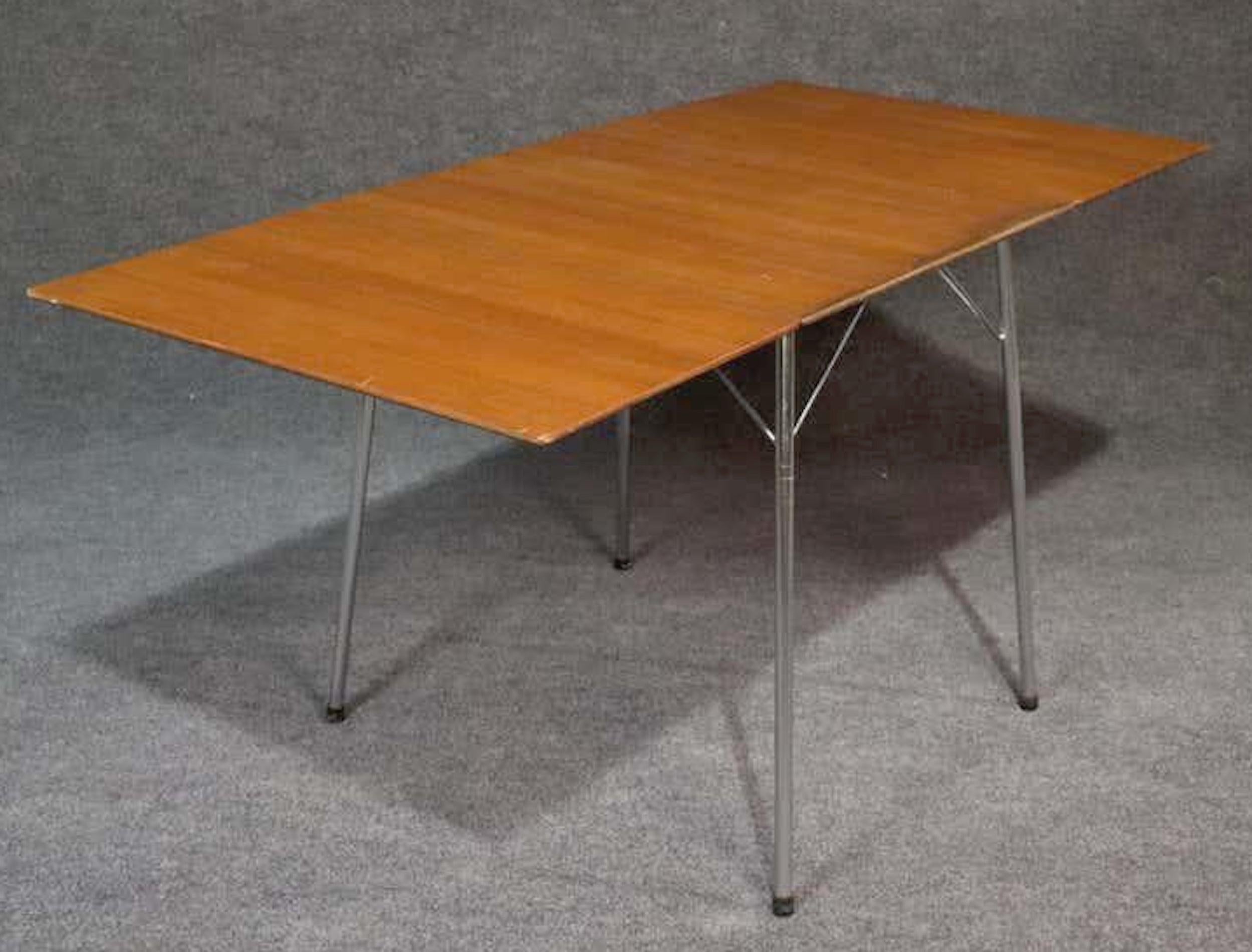 Midcentury Danish modern drop leaf table in teak wood grain. Made for Fritz Hansen furniture company.
Measures: 18