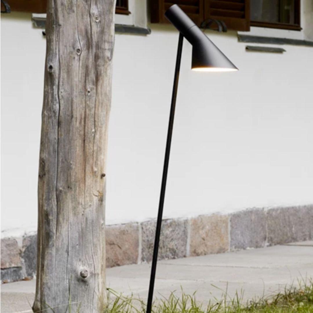 Borne haute 'AJ Garden' d'Arne Jacobsen en noir avec pointe pour Louis Poulsen. 

Conçue à l'origine en 1960 par Arne Jacobsen pour l'hôtel SAS Royal de Copenhague (Radisson Blu), la famille de lampes AJ a contribué au concept de design global de