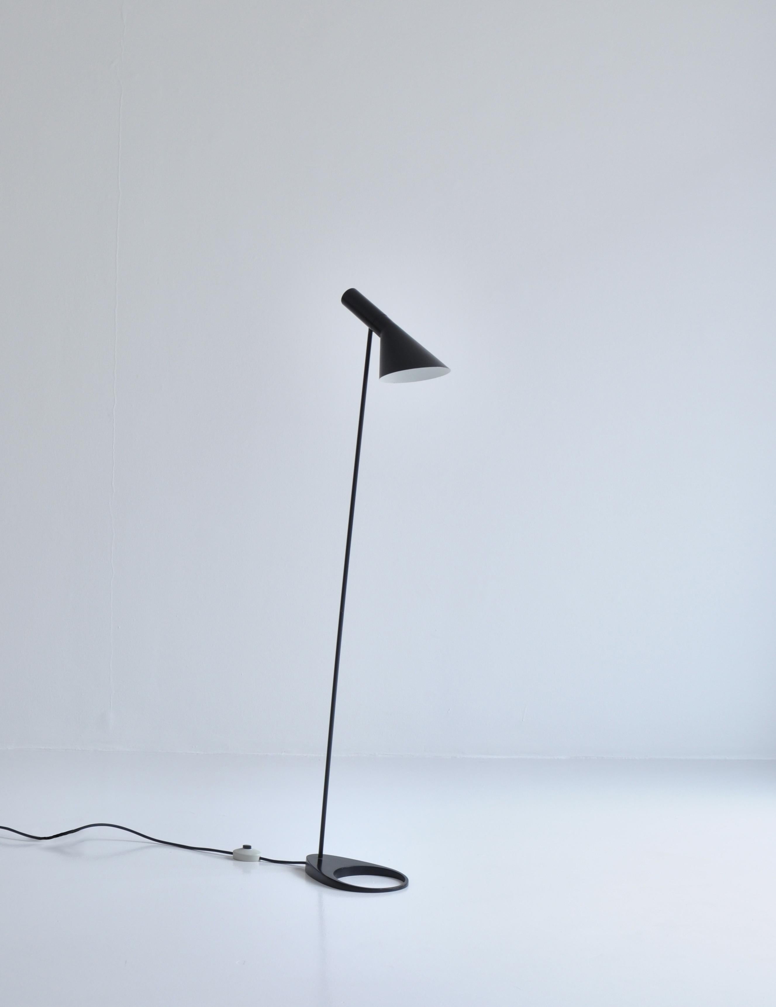 Floor lamp designed by Arne Jacobsen for the SAS Royal Hotel, Copenhagen in 1958 and made by Louis Poulsen Denmark. This lamp is from the early production in the 1960s and still has the original foot switch and wire. It is made from black lacquered