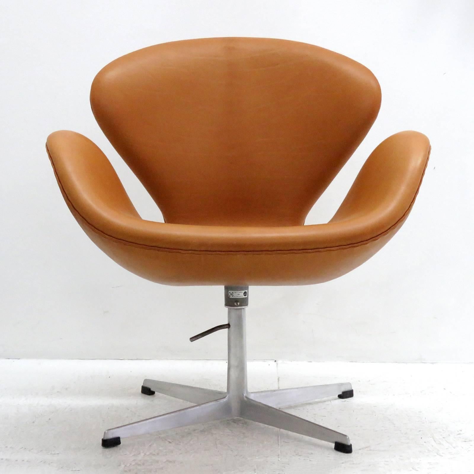 stunning 'Swan' chair, early model 3320, by Arne Jacobsen, lounge chair on a height adjustable four-star aluminum base, upholstered in cognac range aniline leather, originally designed 1957-1958 for the Hotel Royal in Copenhagen, marked Fritz Hansen.