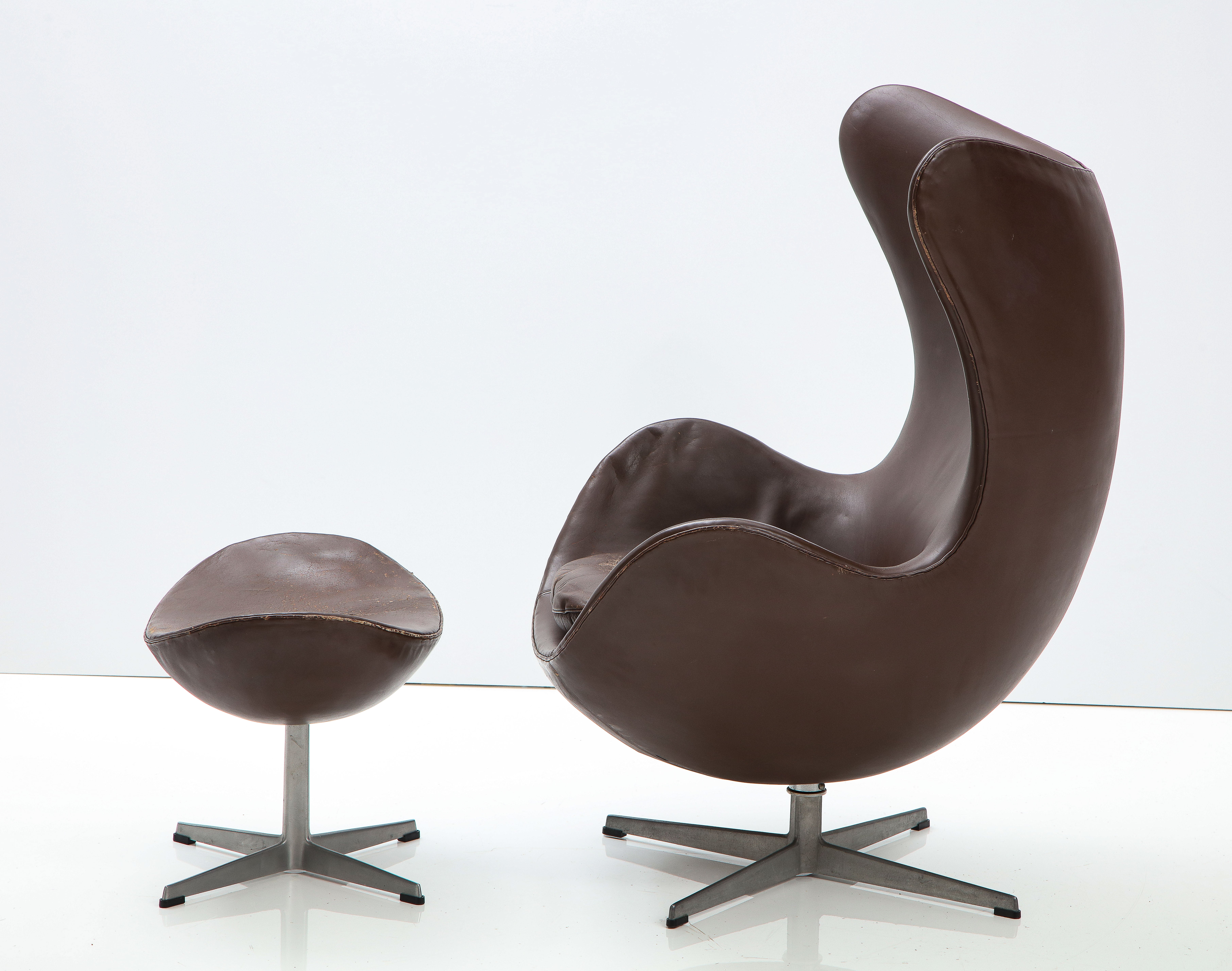 The classic and iconic 'Egg' chair and ottoman designed by Arne Jacobsen for Fritz Hansen, Denmark, 1976. Made in Denmark by Fritz Hansen, 1976. With it's original chocolate brown leather upholstery. 

The Egg was originally designed in 1958 for