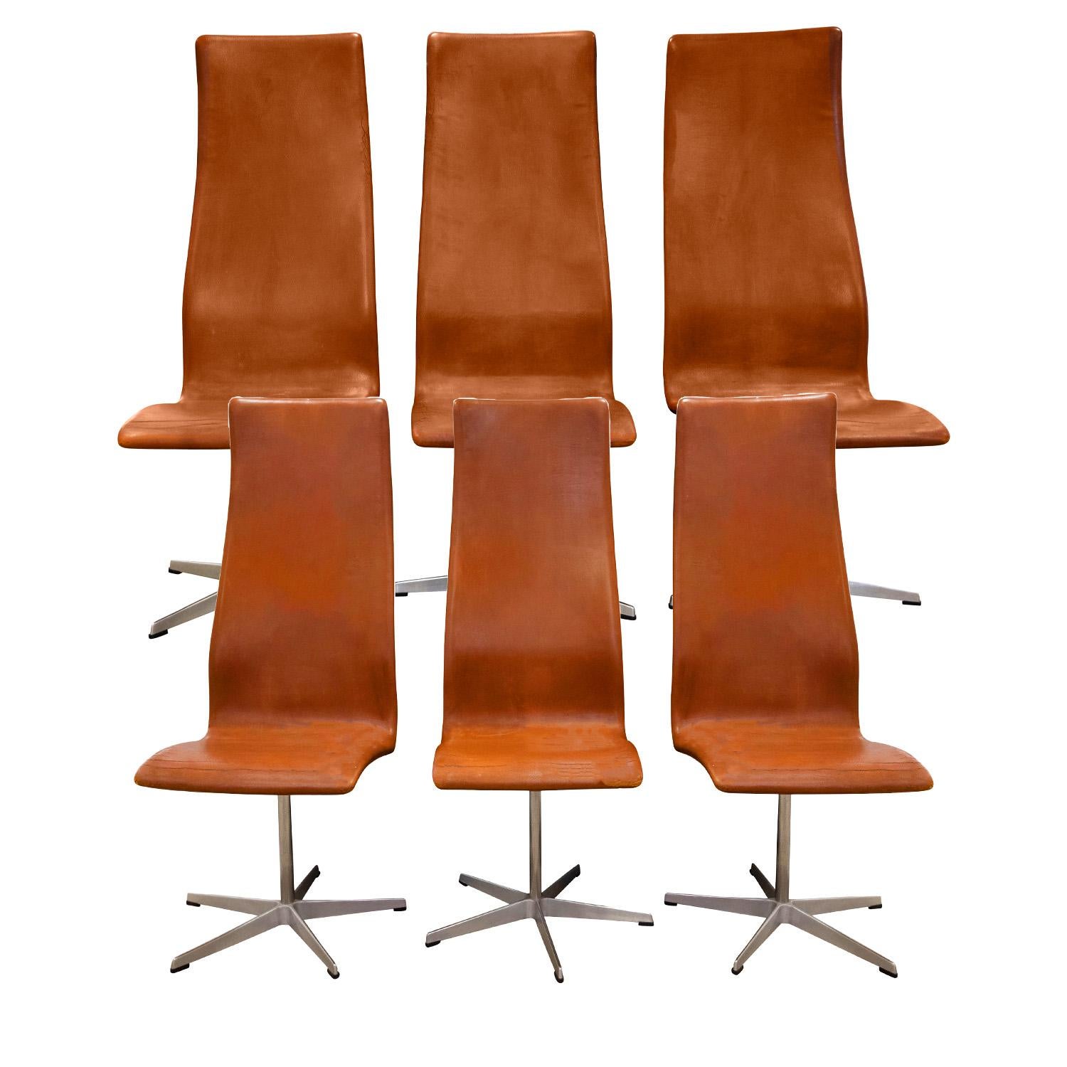 Set of 6 early production high back Oxford dining chairs in original camel leather with steel bases by Arne Jacobson for Fritz Hansen, Denmark 1960's (Signed “FH - Made in Denmark” on faded label on bottom). The original leather has patina and